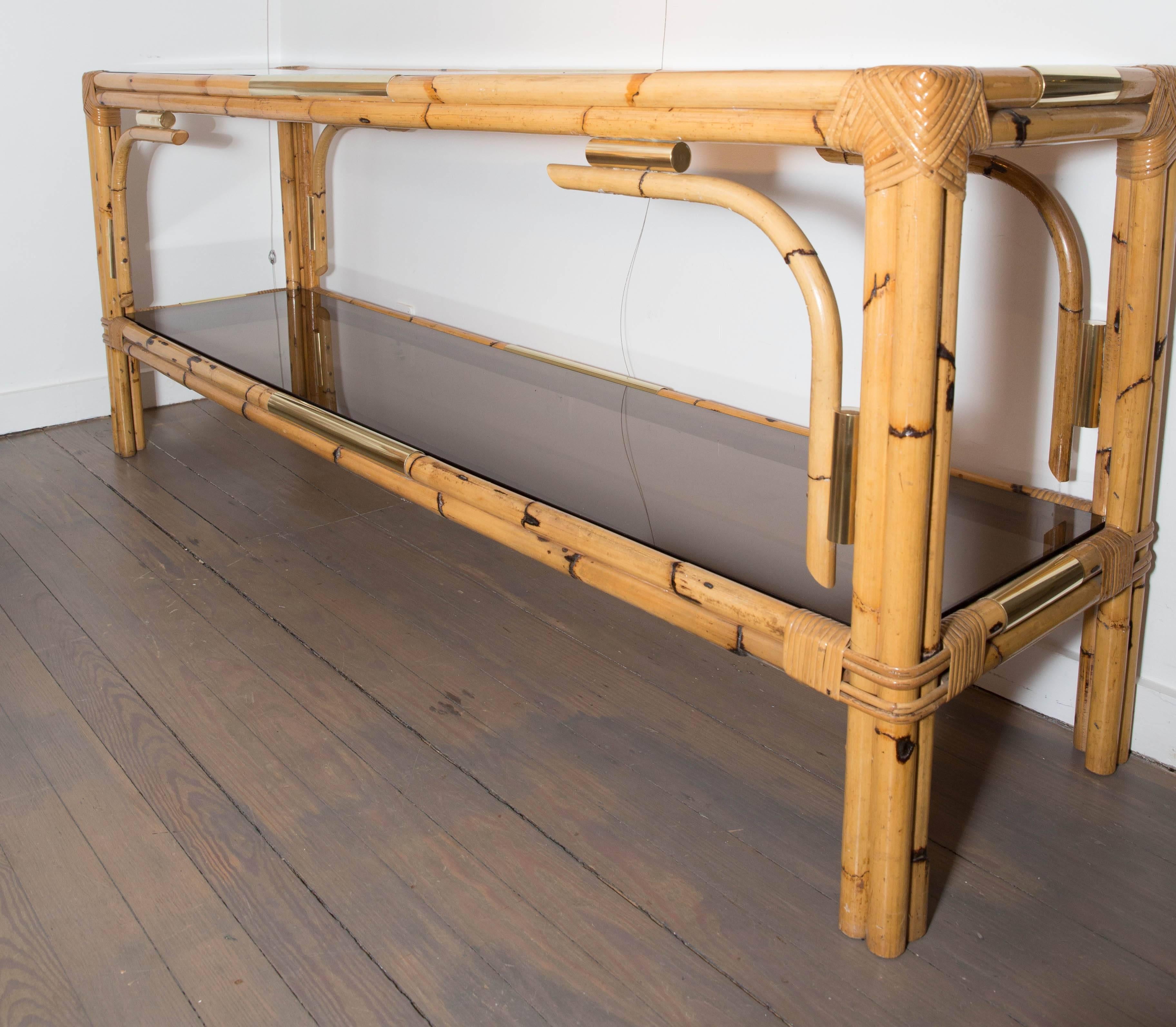 Bamboo console table with two tinted glass shelves and brass detail.