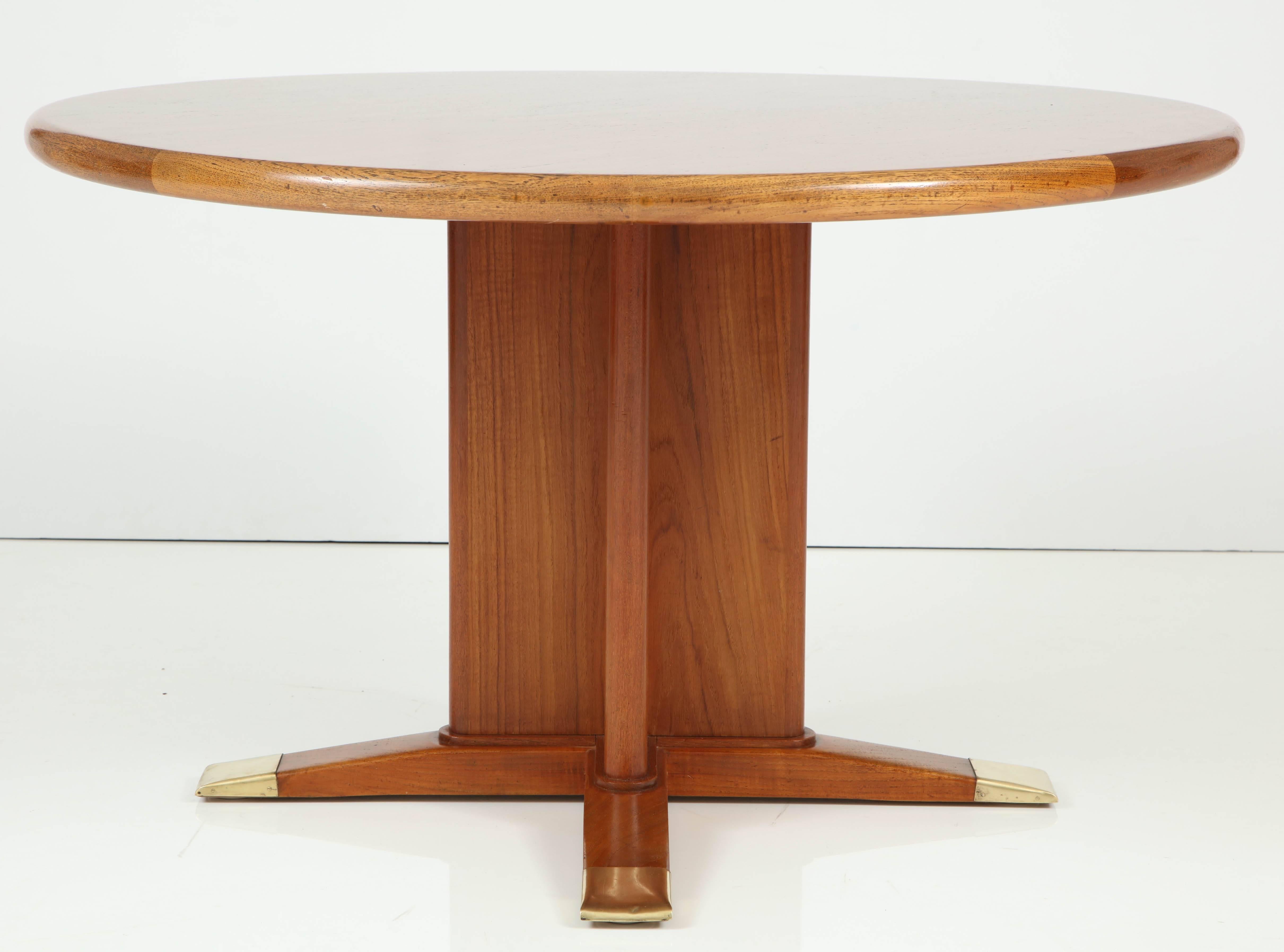 A Danish stained oak and brass pedestal table designed and produced by Frits Henningsen, circa 1940s, the circular top raised on a cross form pedestal and four chamfered feet ending with brass caps.