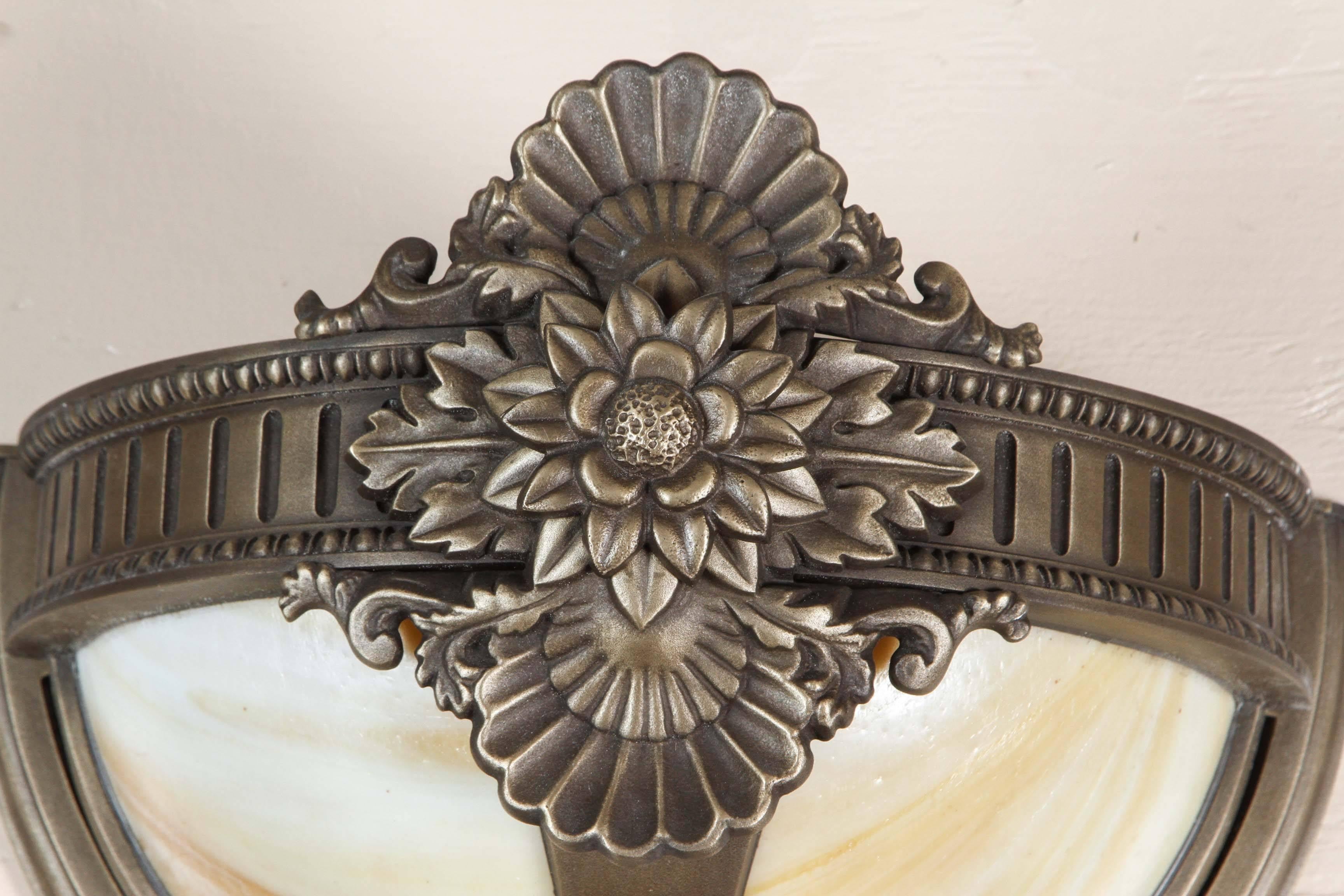 Bronze wall sconce with slag glass in a floral design. Several available at time of posting. Priced each. Please inquire. This can be seen at our 1800 South Grand Ave location in Downtown Los Angeles.