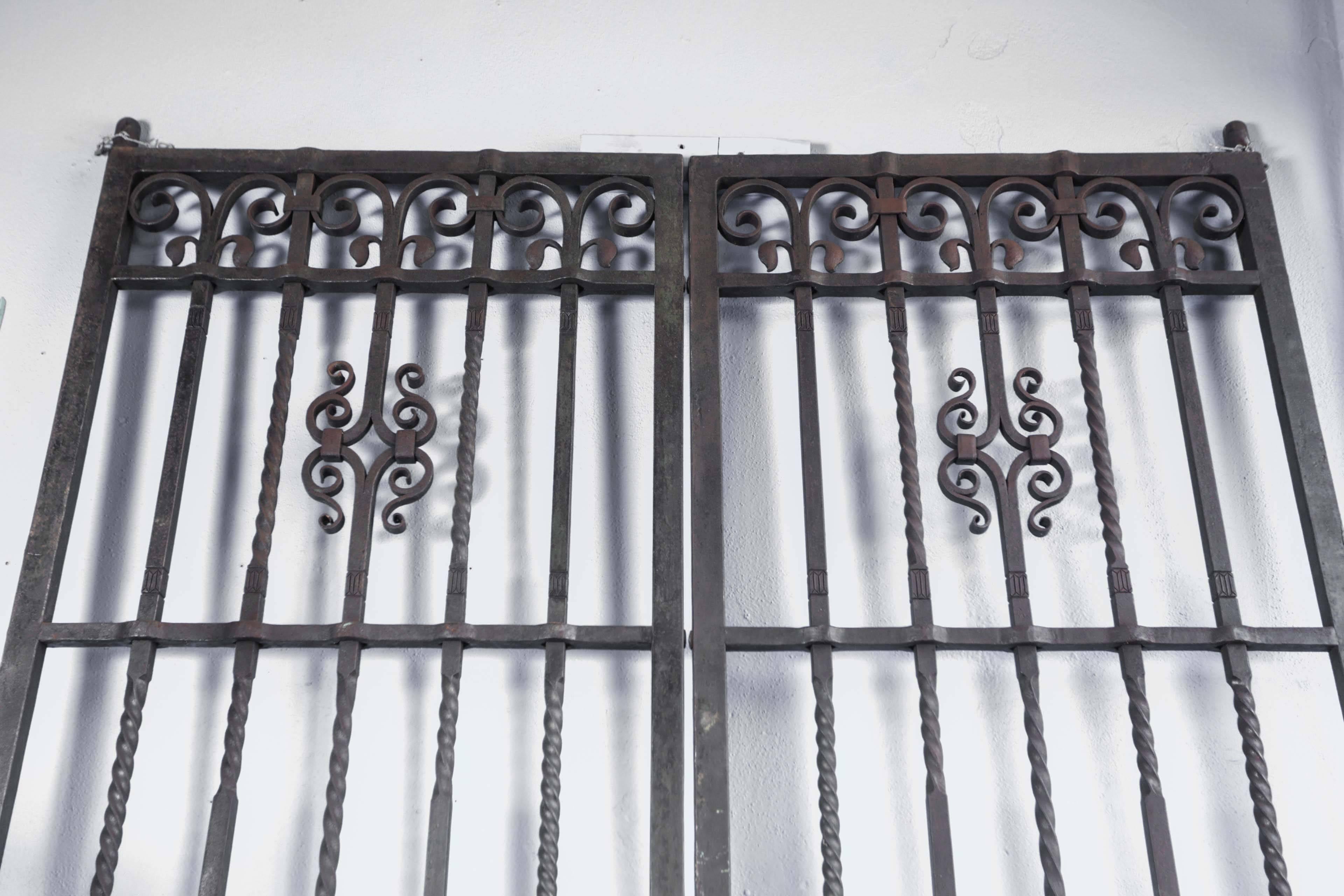 Pair of 1910 wrought iron gates by Samuel Yellin, considered to be one of the greatest artist blacksmiths. Salvaged from a Philadelphia bank. The frame of each door is exactly 118.25 in. tall and 35 in. wide, and the frame itself is 1.25 in. thick.
