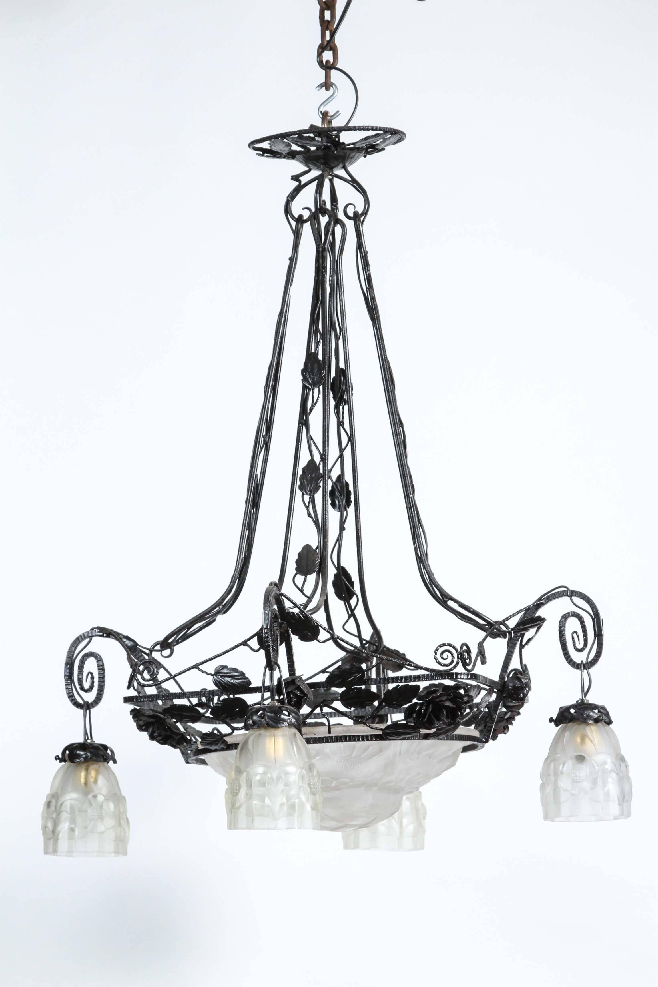 Wrought iron and frosted glass four light floral motif chandelier. Centre bowl is not lit.  Please note, this item is located in our Los Angeles location.
