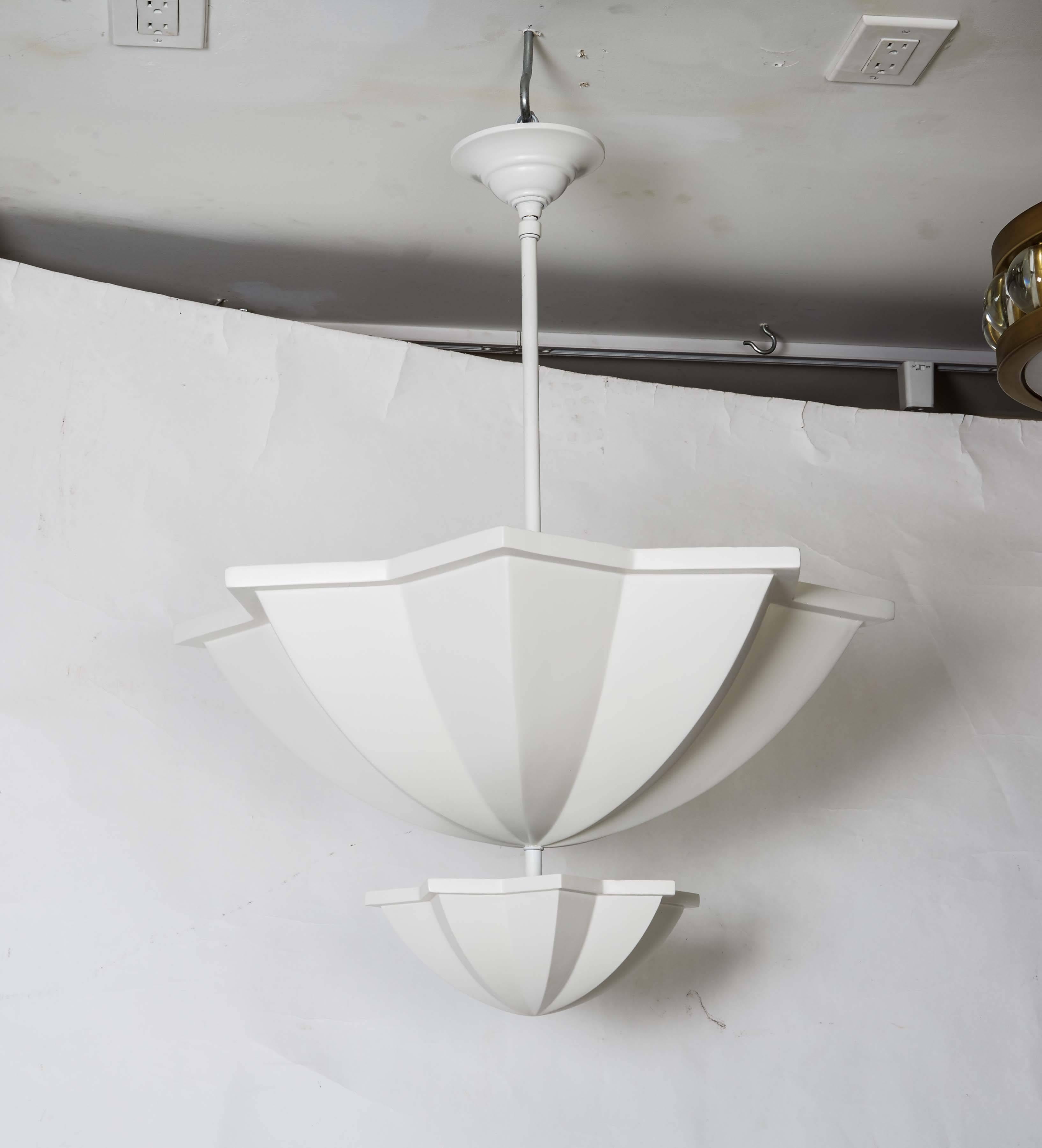 A two-tiered ceiling fixture inspired by the Moroccan star design made of aquaresin and brass with a chaulky white plaster-look painted finish. The larger section conceals four Edison base sockets with a max of 100 watts per bulb, and the smaller