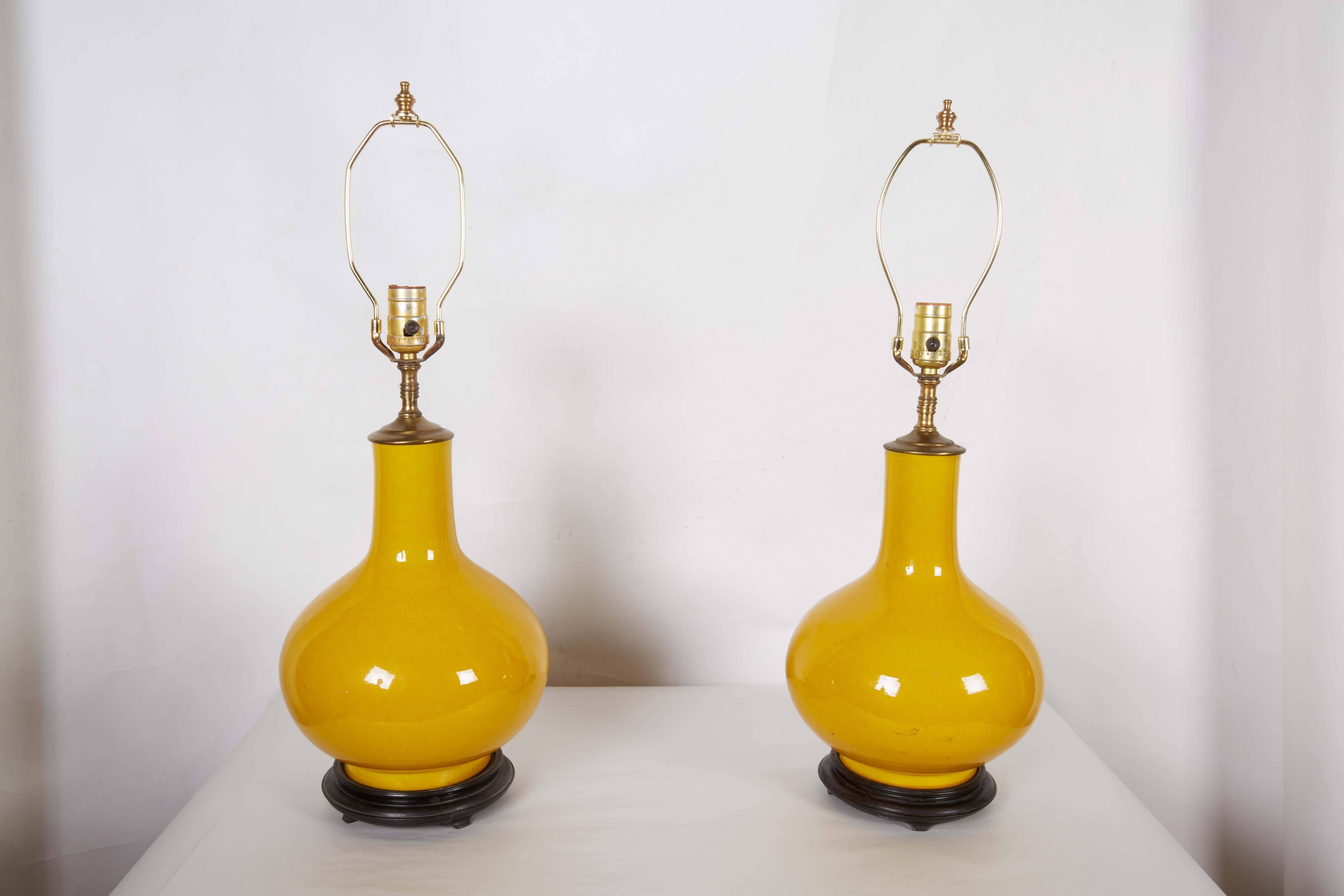 A pair of Chinese yellow glazed vases fitted as lamps, on circular stepped wooden base, circa 1970.

25