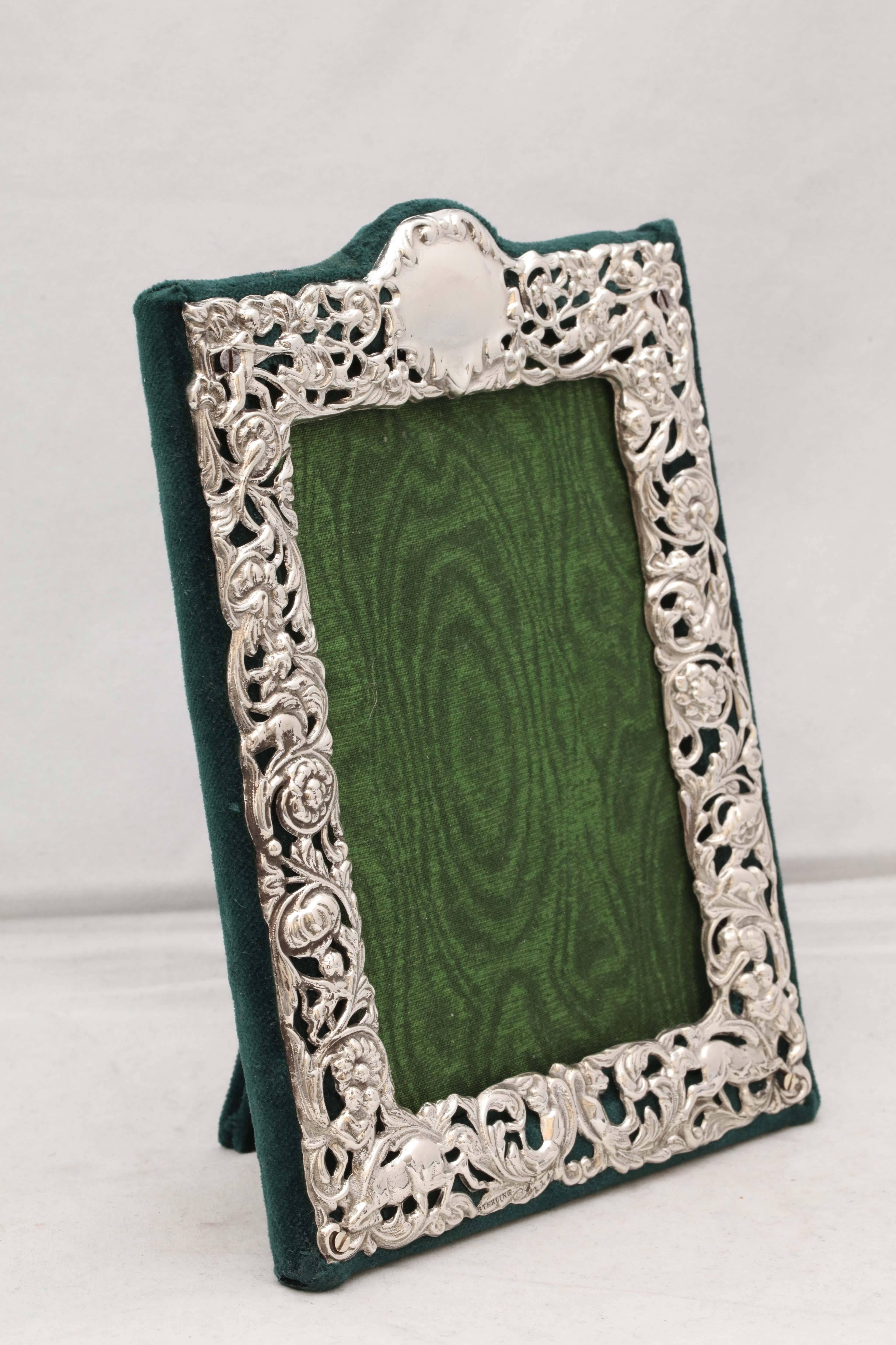 Victorian, sterling silver picture frame, Dominick & Haff, New York, circa 1895. Lovely pierced work, depicting flowers (there are two horses on either side of the bottom), allows the dark green velvet to show through. Vacant cartouche. Measures: 7