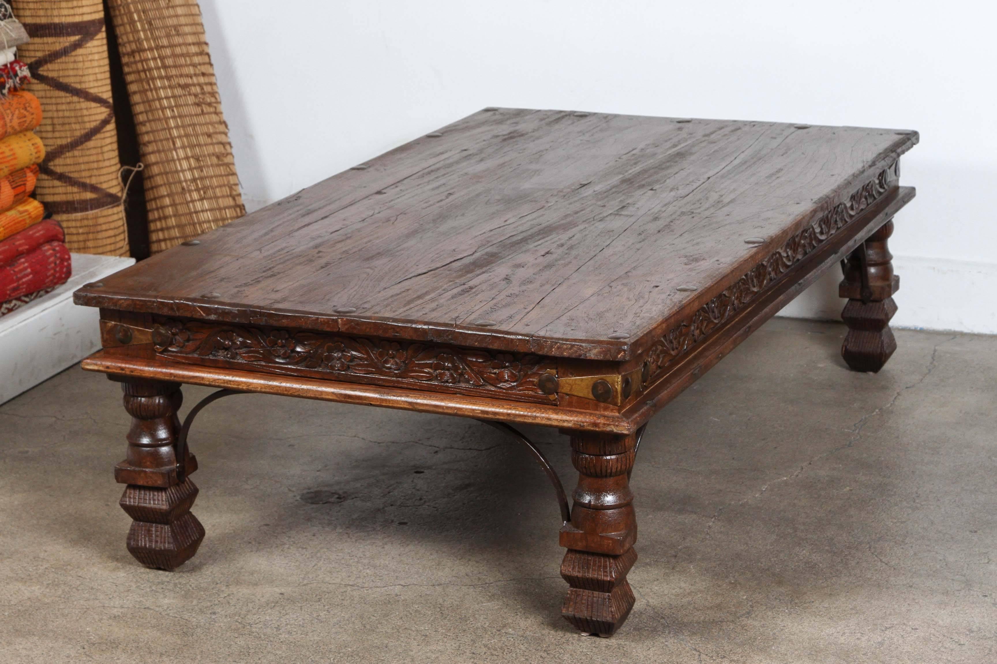 Large vintage Anglo-Indian teakwood rectangular coffee table.
Large rounded nailheads and metal accents support, very nicely carved legs and sides and the corners are reinforced with metal iron pieces.
Spanish Portuguese colonial style.