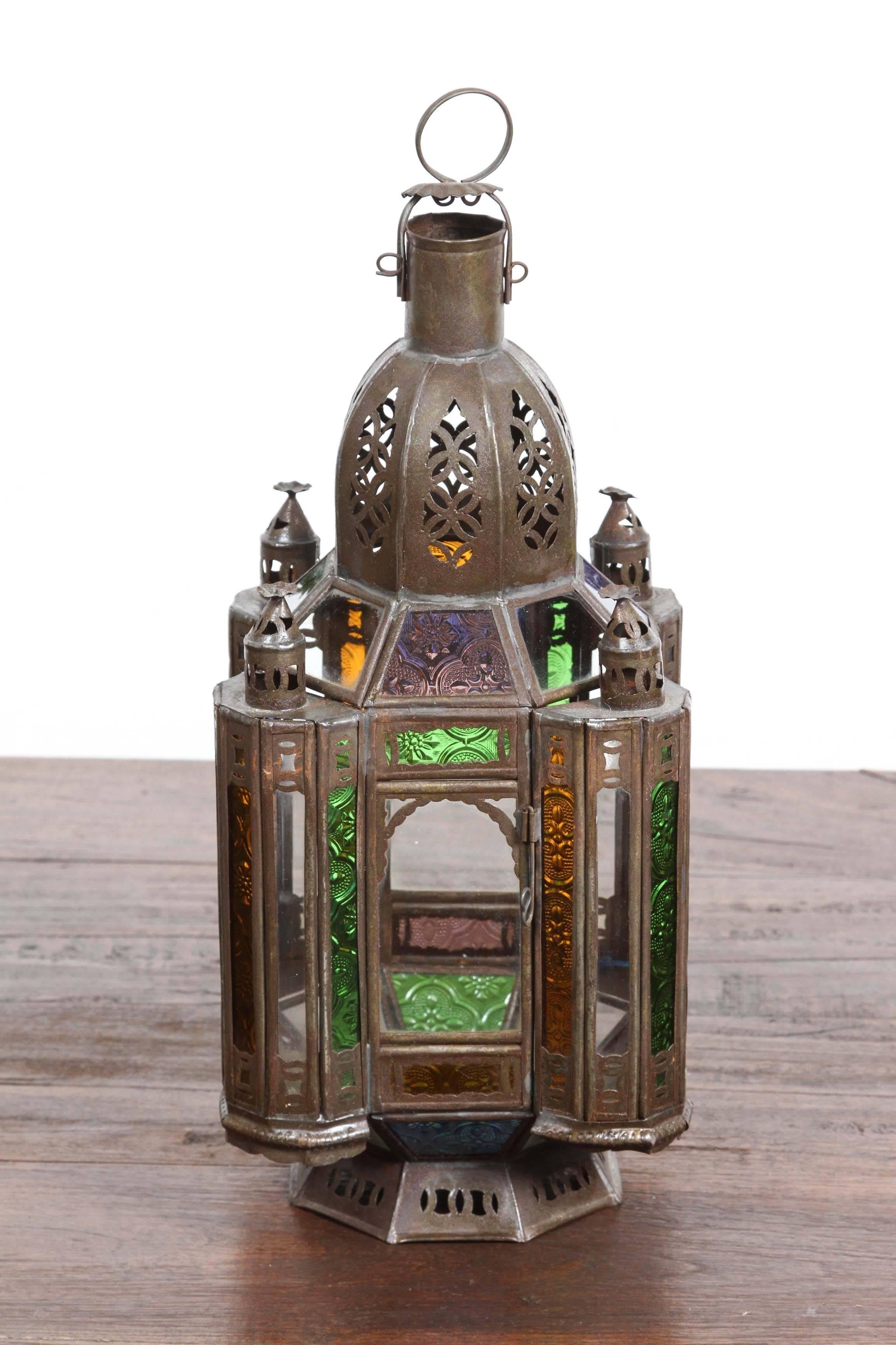 Handcrafted metal Moroccan lantern with clear and colored glass in blue, green amber and lavender.
Hurricane candle lamp square metal lantern with octagonal base, there is a small door on the side that open for easy access to add a candle, and has a