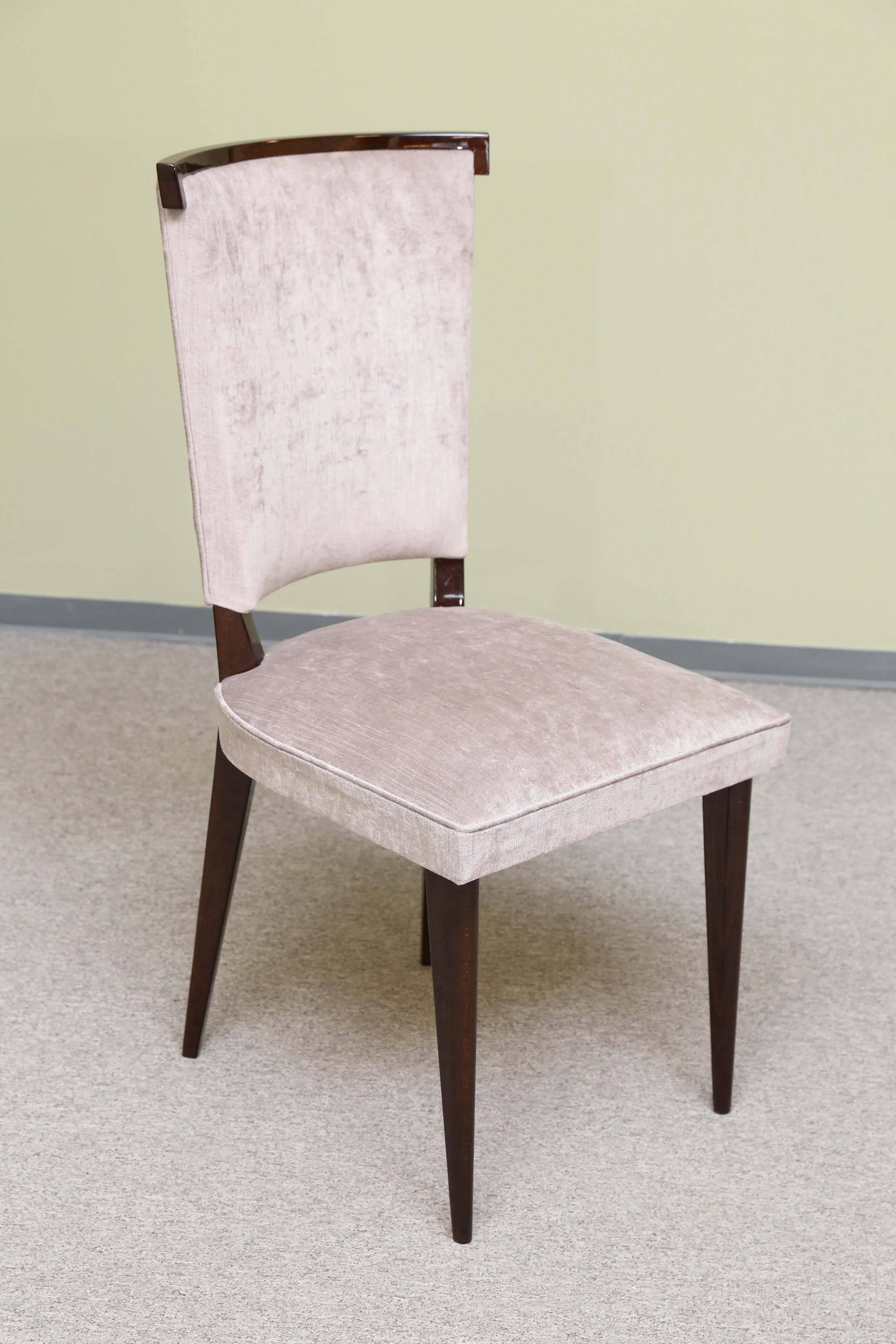 Set of eight dining chairs made out of beechwood. Re-upholstered in a light beige fabric. Each chair is elevated by the slim rectangular legs. Top of the back part is decorated with a wooden trimming. 
 Condition is excellent.
Could be sold