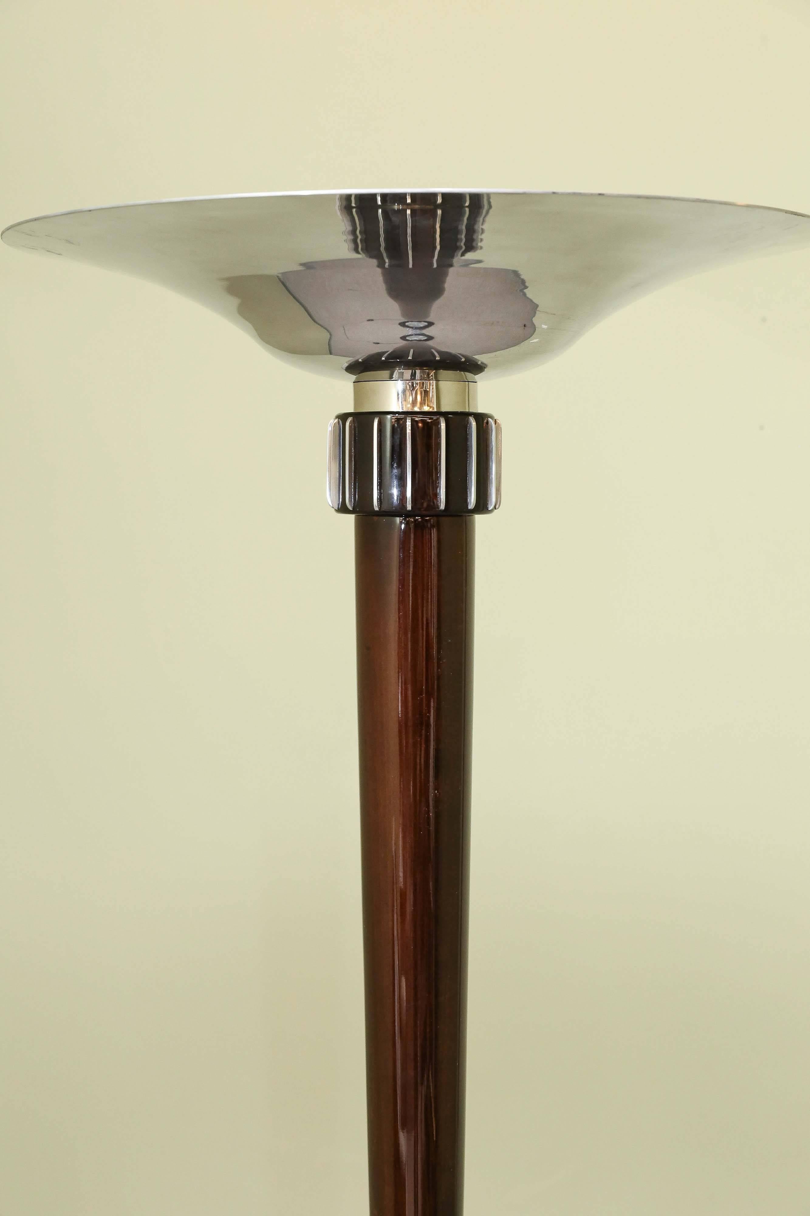 Funnel shape chrome lampshade is connected to the main pole and with a help of one chrome insert transfers to the wooden thick stabile base of the lamp. Due to the highly polished chrome, the light strongly irradiates and spreads through the space