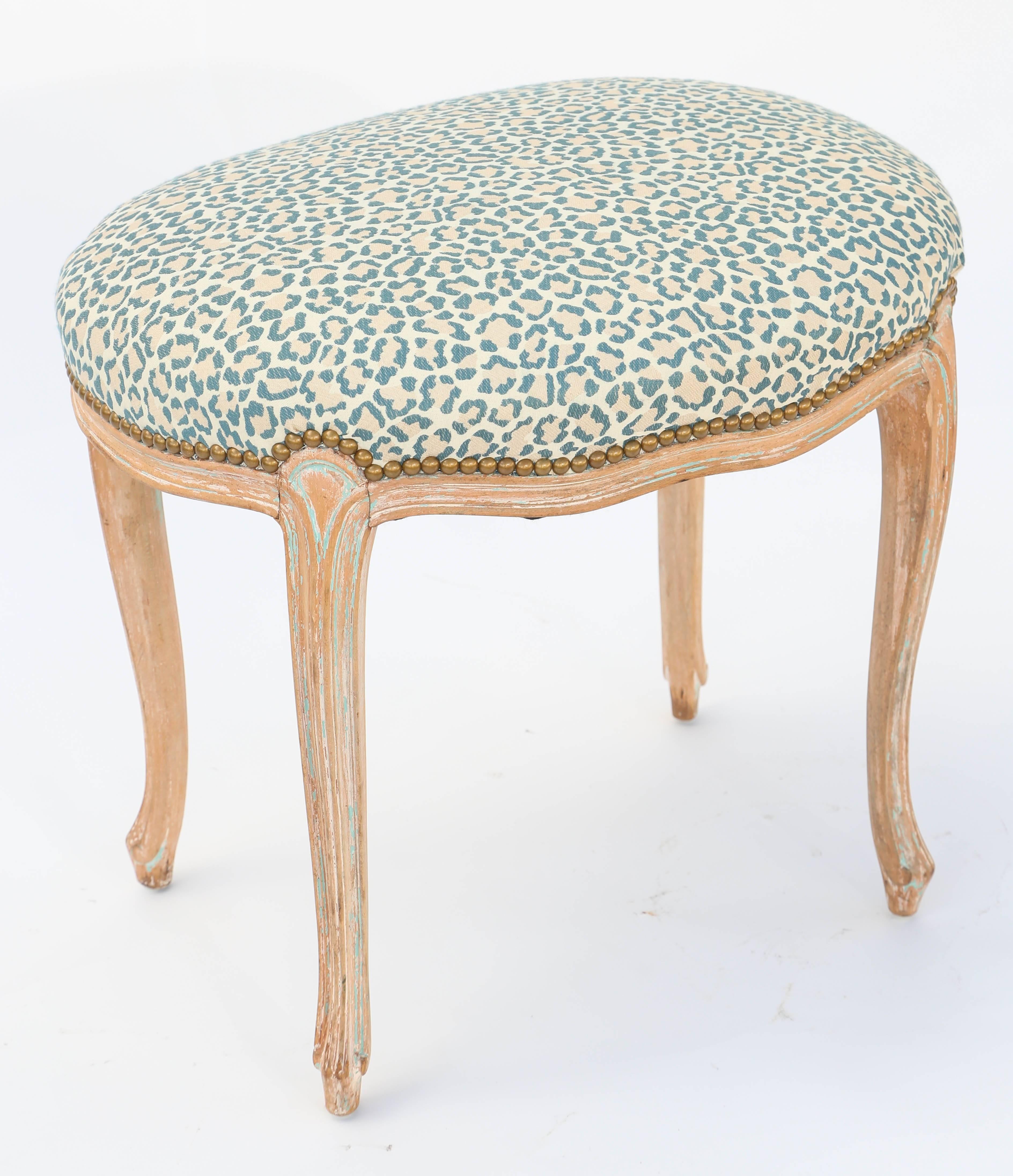 Oval stool, having a crown seat in leopard-print fabric, finished with nailheads, on a frame with a pickled, natural wood finish, its channelled apron, raised on slight cabriole legs, ending in touipe feet.

Stock ID: D9423