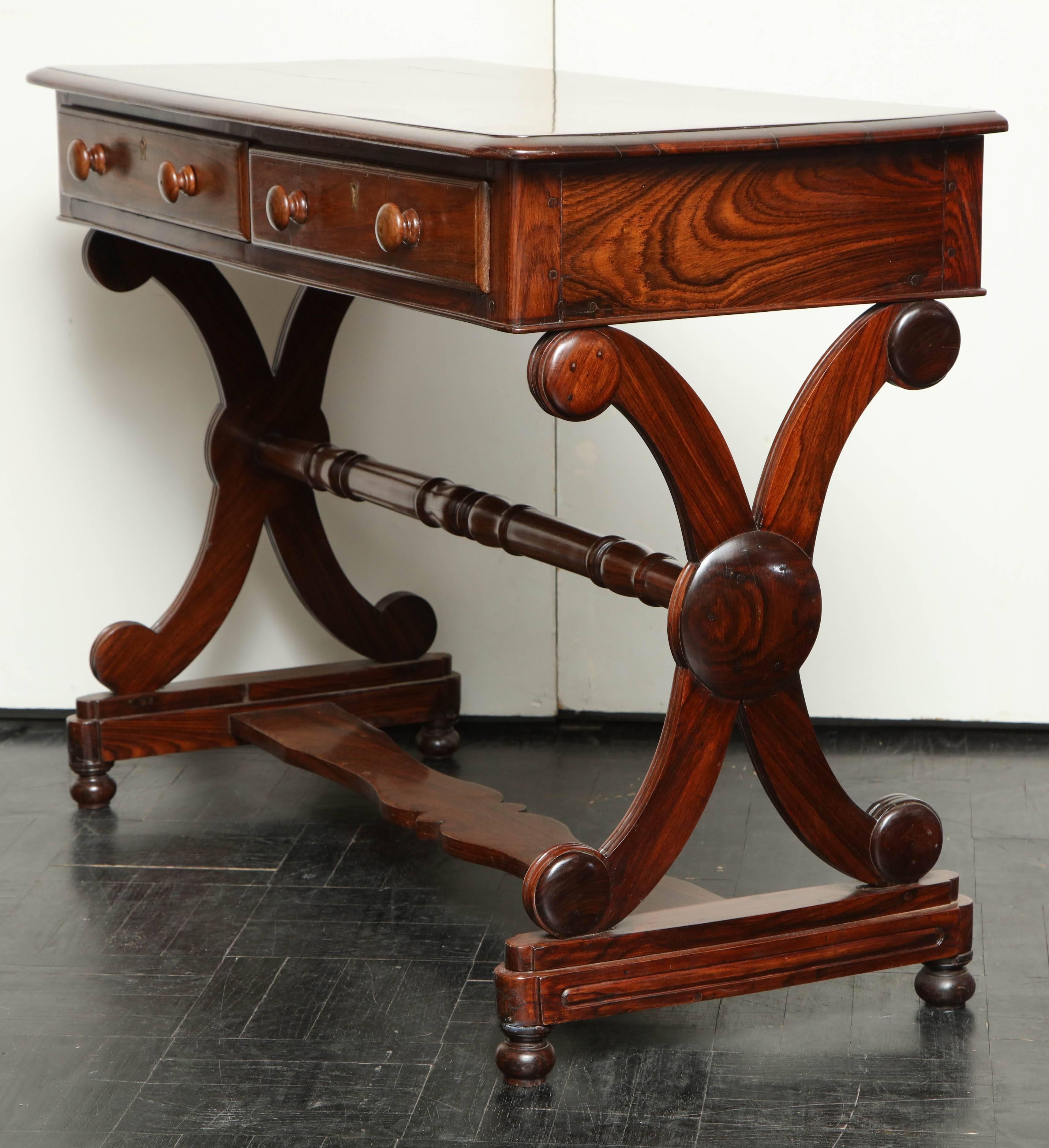 19th century, rosewood Anglo-Indian sofa table, polished and molded top above two drawers in apron, ivory escutcheon, trestle base joined by turned stretcher X-shaped sides.