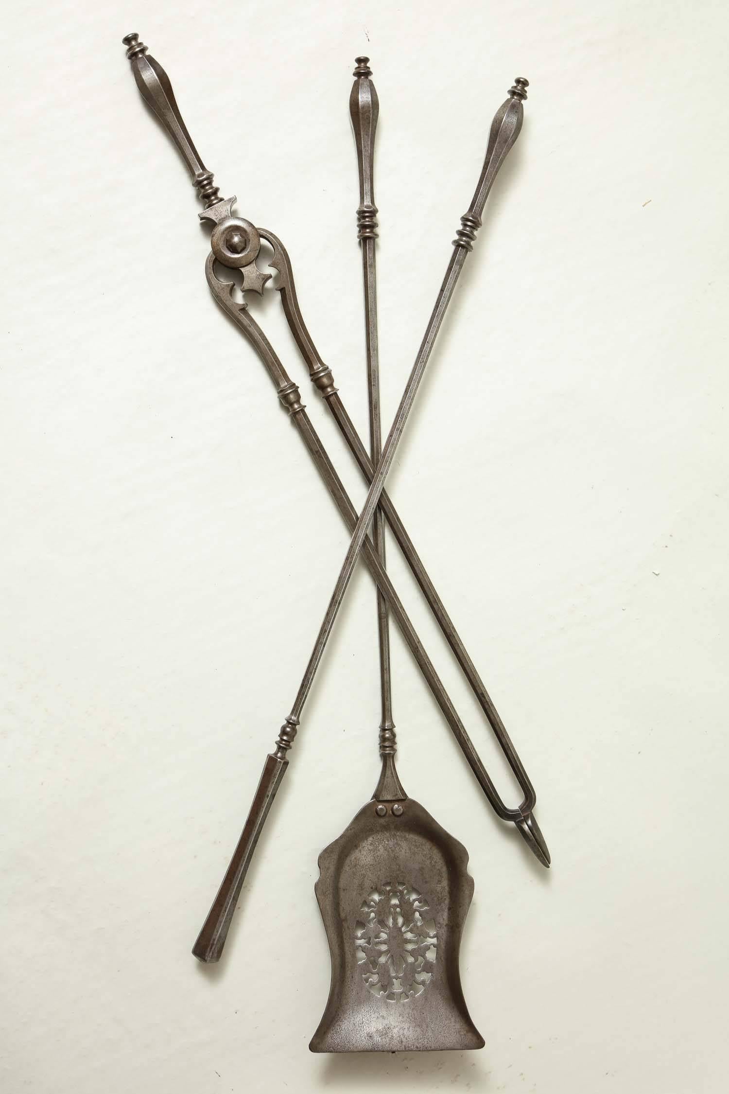Fine set of 19th century steel fire tools comprising a pierced shovel, poker and pair of tongs, the former with oval paterea and foliate design, all with octagonal tear drop handles and octagonal shafts and with nicely patinated surface.