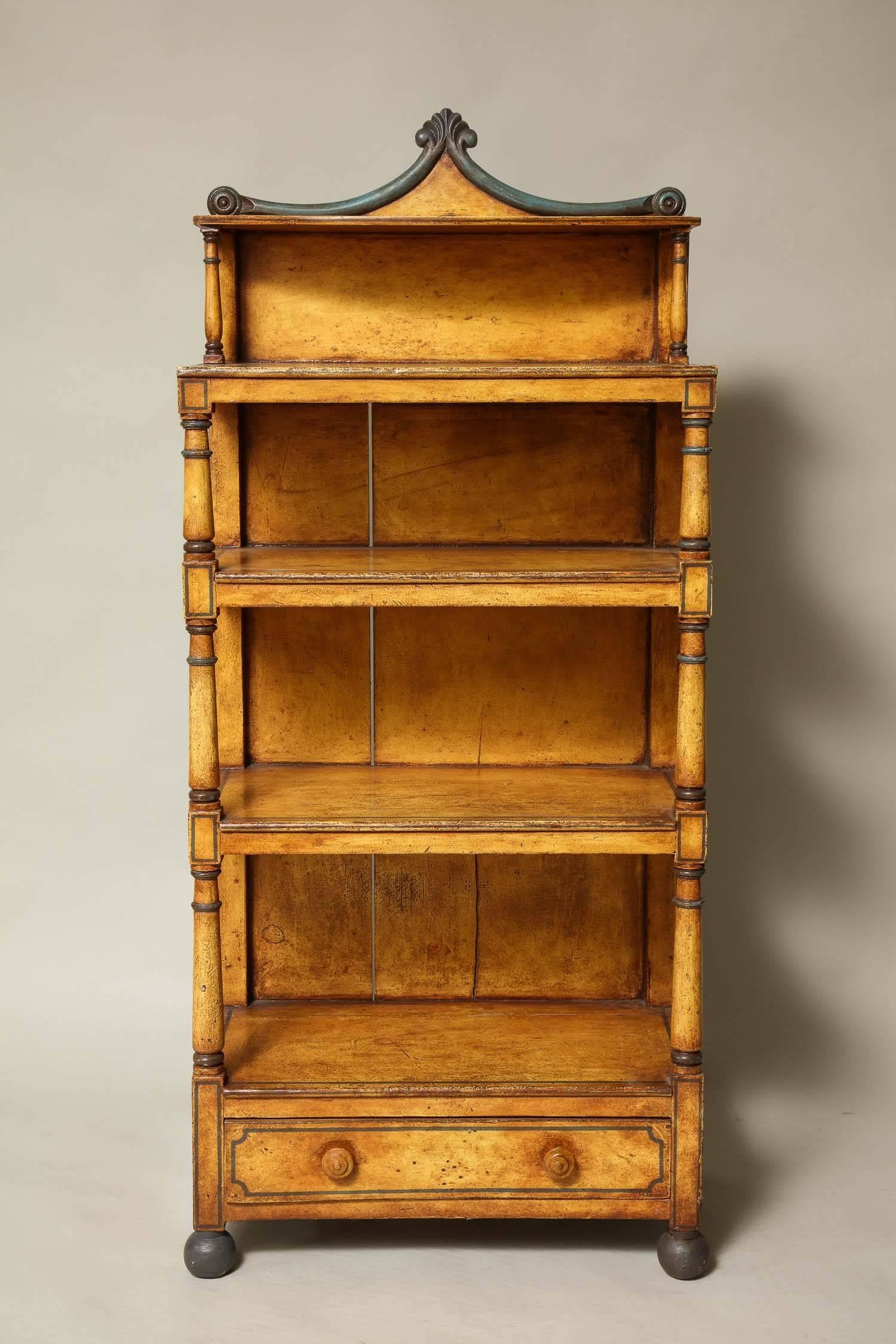 A 19th century English four-tier bookcase having column supports and a decorative crown all-over a bottom drawer and standing on ball feet. In an attractive grain paint with dark green highlights. A useful piece with good proportions.