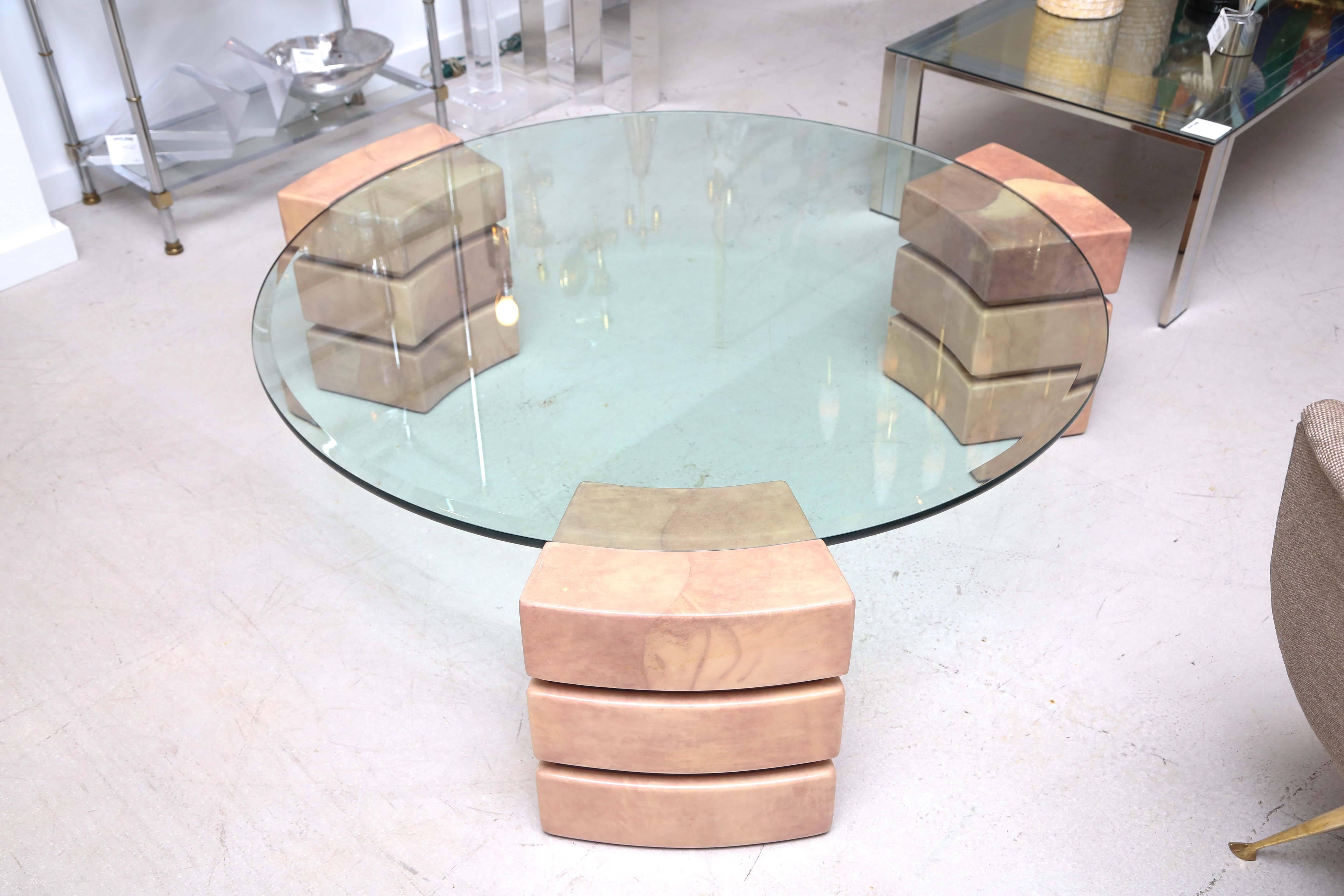Vintage circular coffee table with three stacked lacquered goatskin supports which receive the glass top.