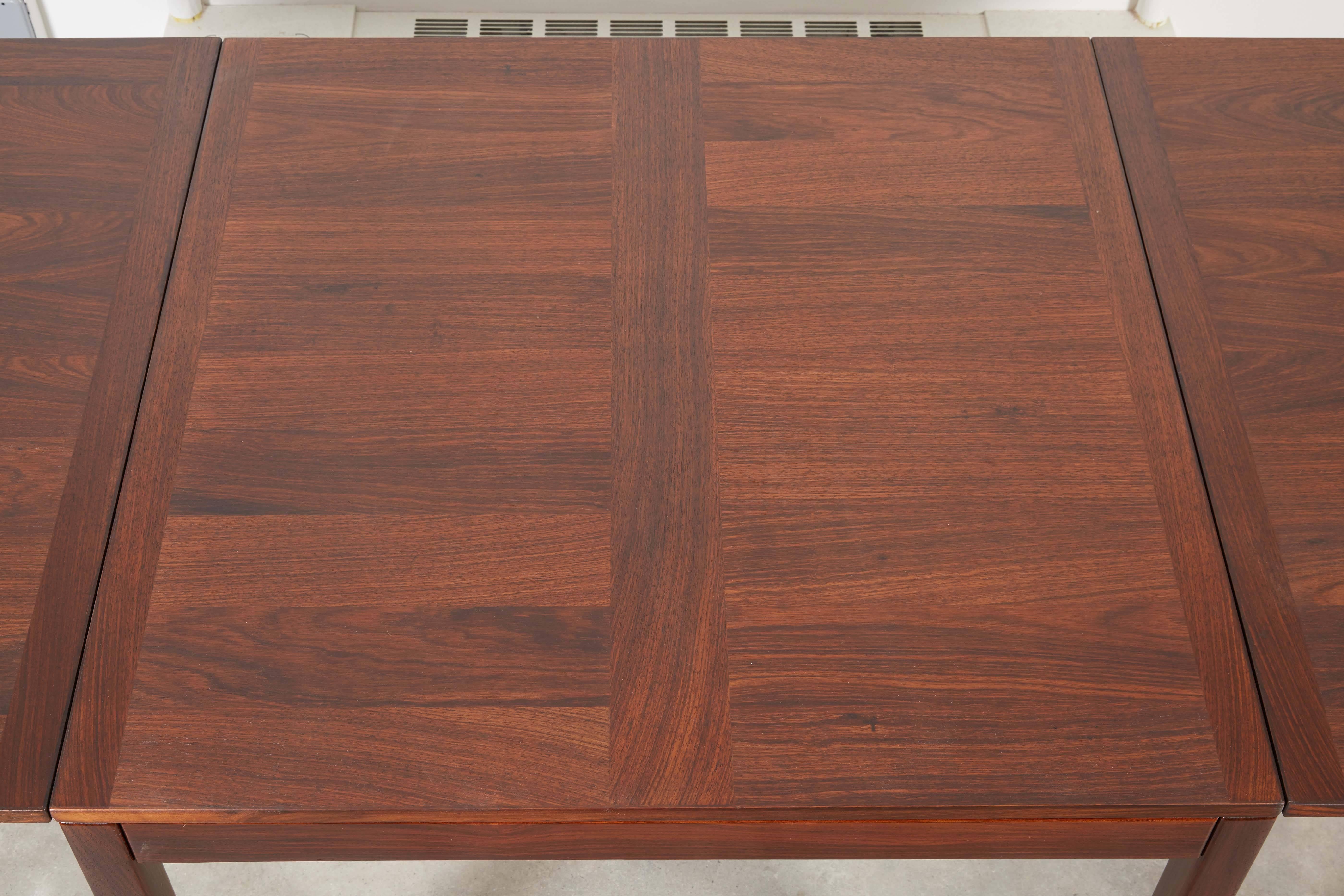 Vintage Kai Winding Dining Table with Drop Leaves.

This Vintage Dining Table has two side leaves that drop down on either side. You can only fit two people if the leaves are down, but hold on to your hat as it grows to five people then to eight