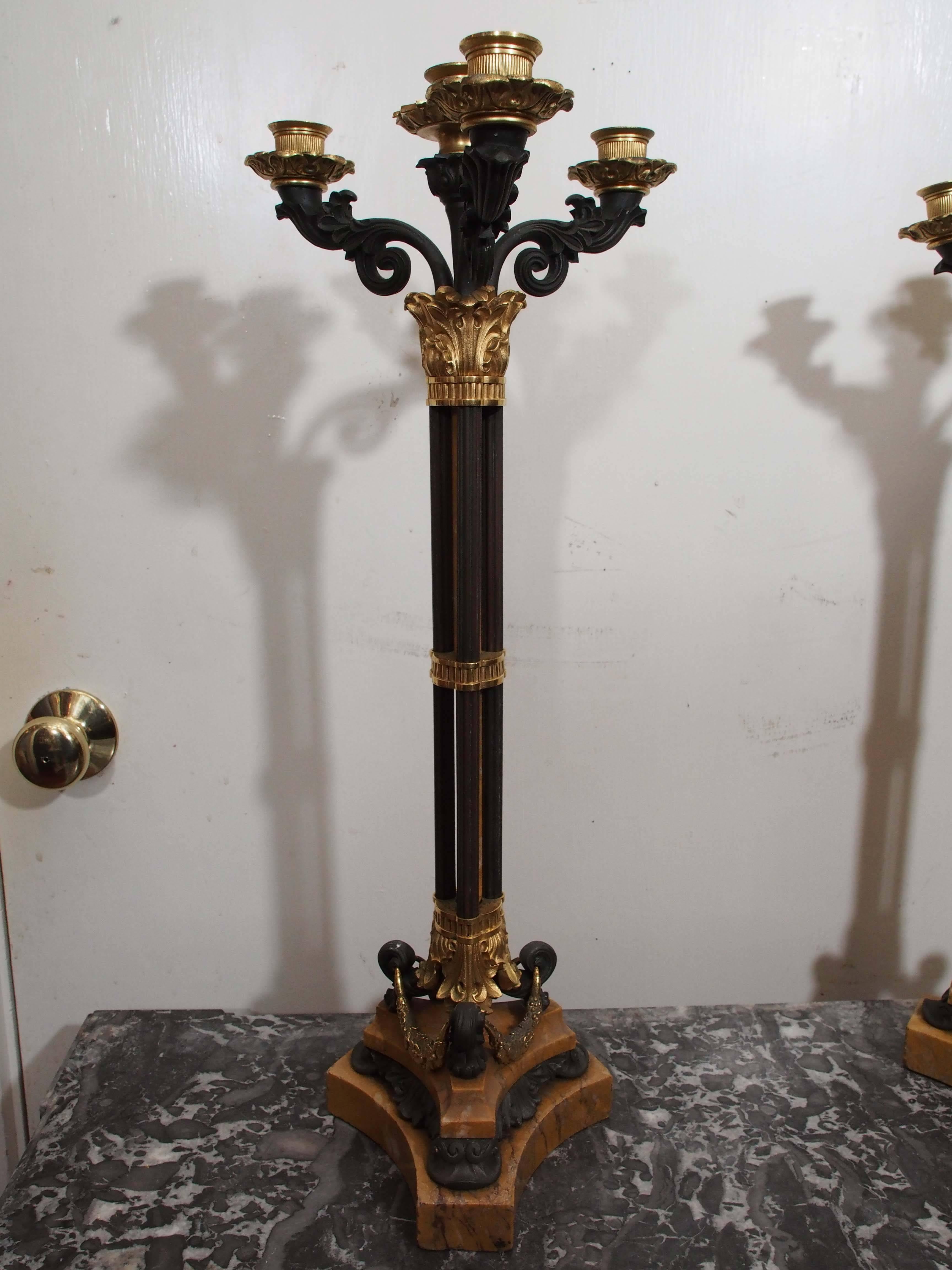 Pair of patinated and gilt bronze / Sienna marble Charles X four-light candelabra.
The cluster column central stem is three patinated columns banded with gilt bronze and having a central sienna column being surrounded. All on animalier legs on a