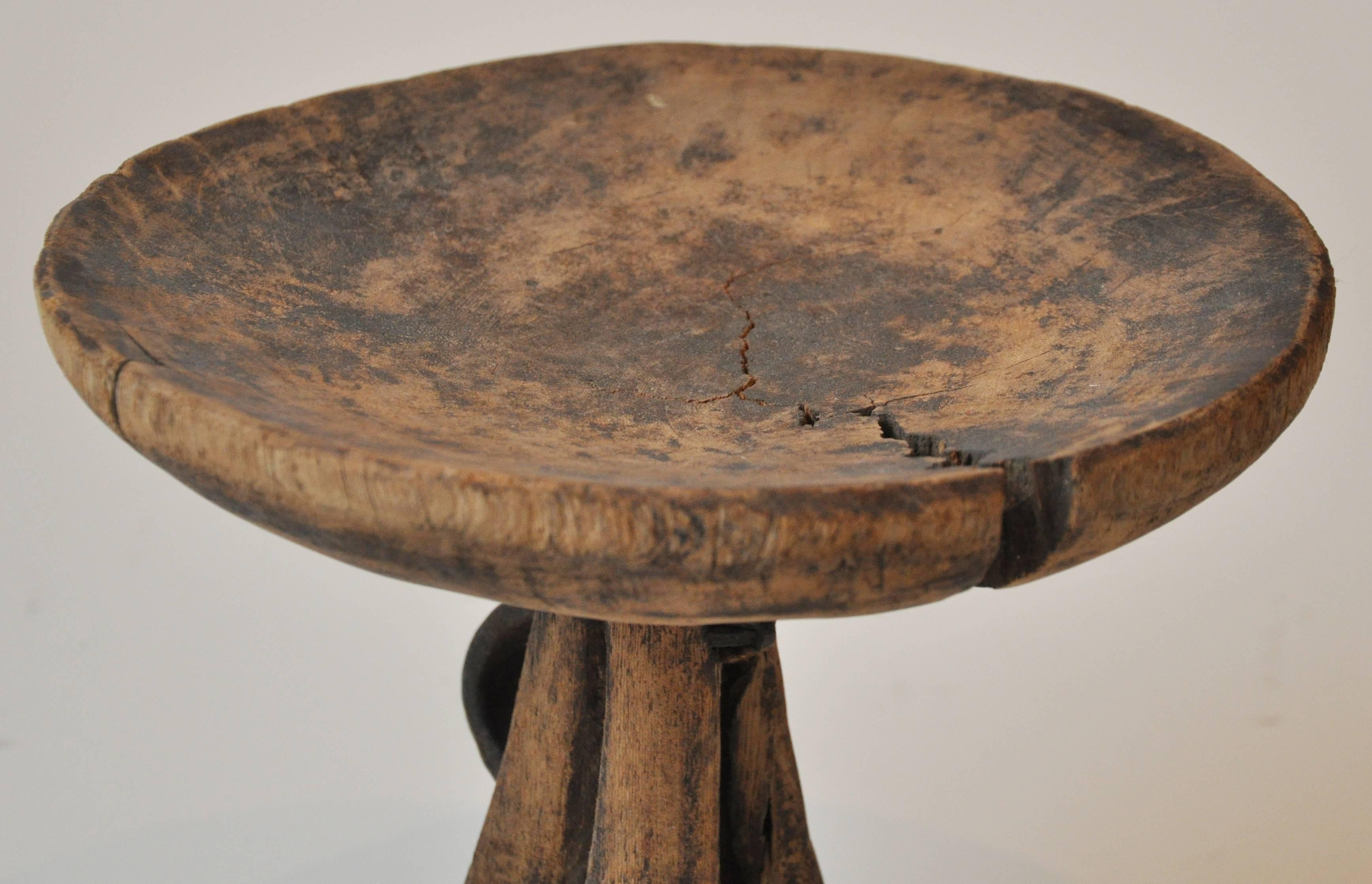 20th century African food serving tray. Handcrafted from wood. The pedestal features a metal handle. Naturally aged and discolored from use. Crack does not impact the structure of piece. 

 