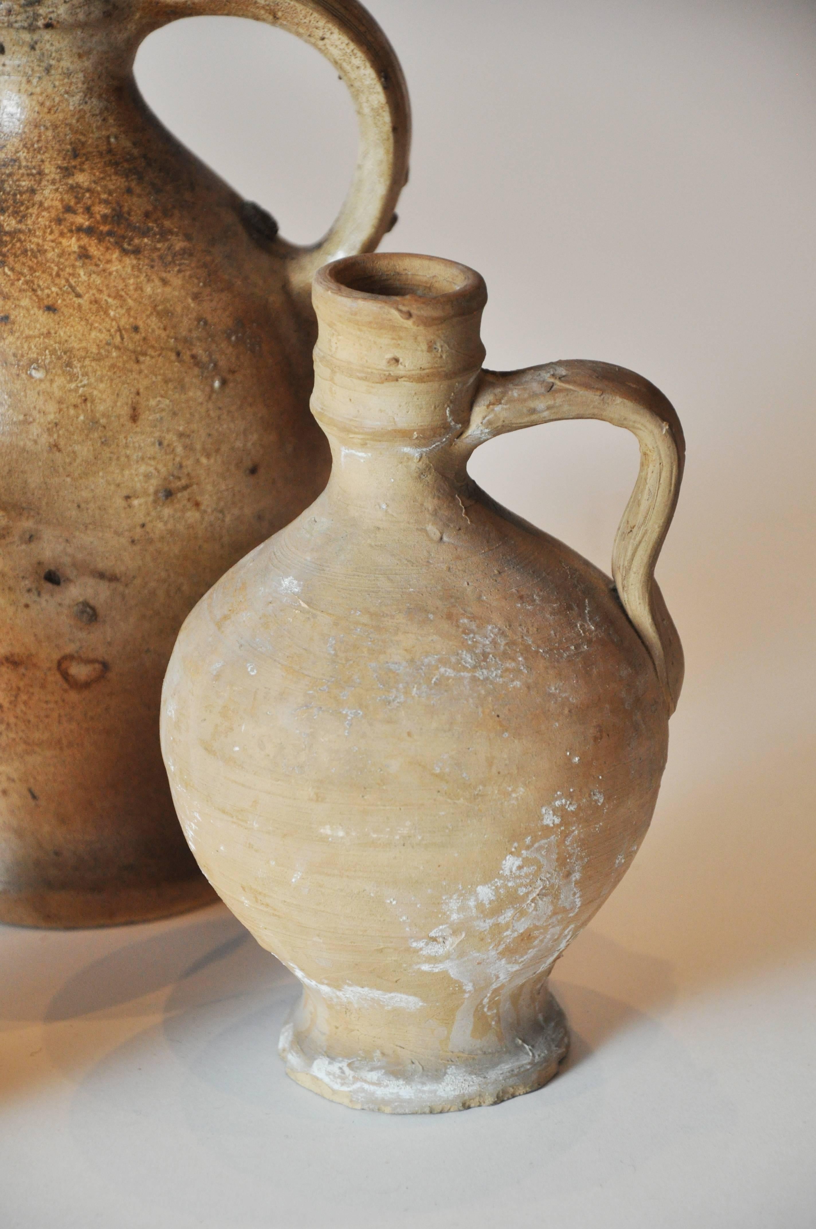 Early 20th century clay pitcher collection from Portugal
Small clay/terra cotta vessel with handle clay pitcher with a repair at the spout
Light brown and beige pitcher with handle, small repair at top
These could be quite old but given I have no