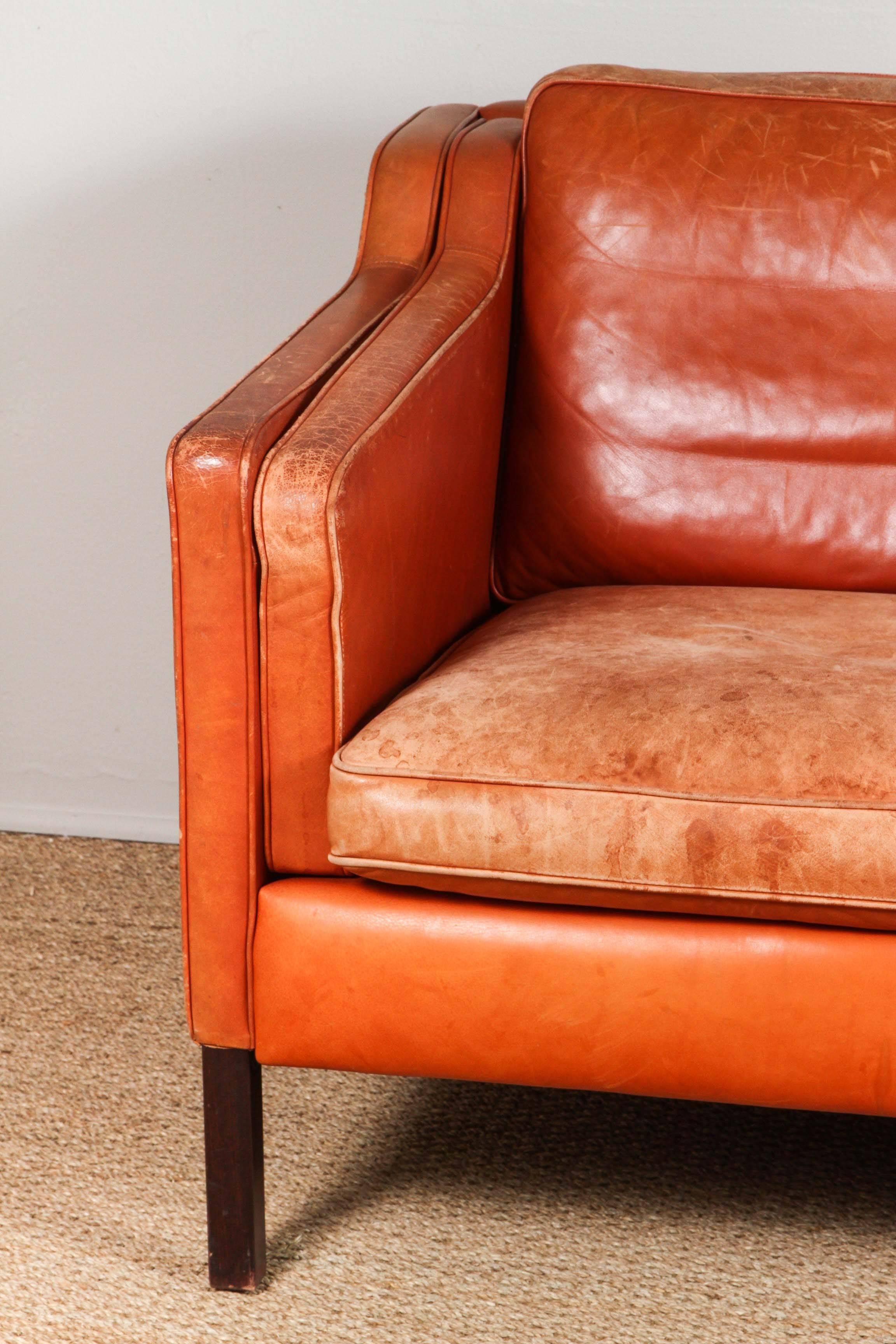 Distressed leather upholstery. Worn especially on seat cushions but no rips, holes or split seams.