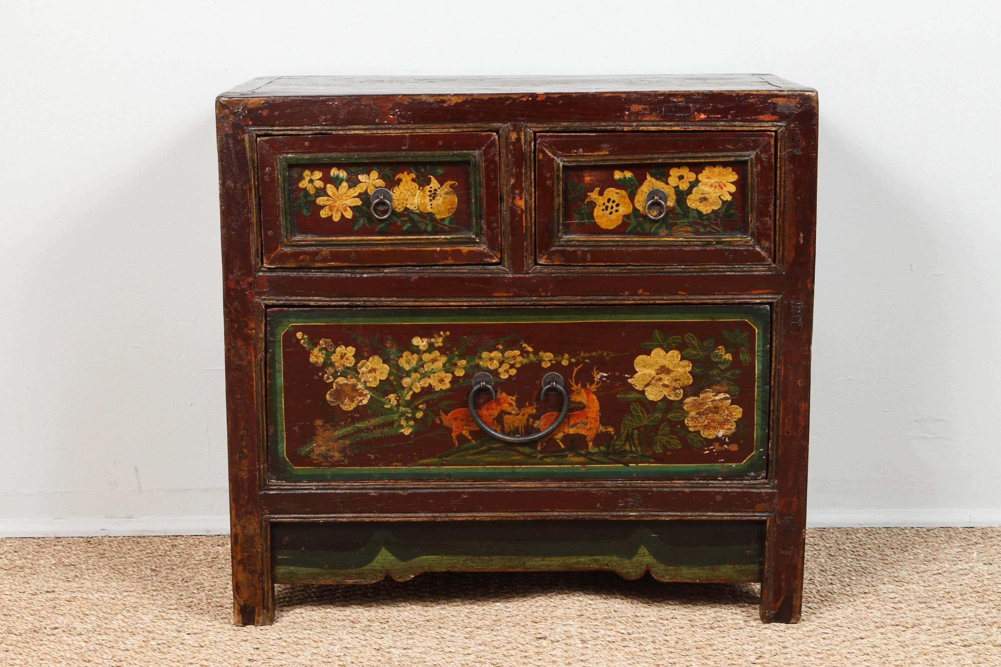 Small three-drawer chest. Flowers, fruit and three deer hand-painted motif. Warm colors. Green, yellow, orange and brown. Original hardware. Sturdy condition with slightly distressed finish.