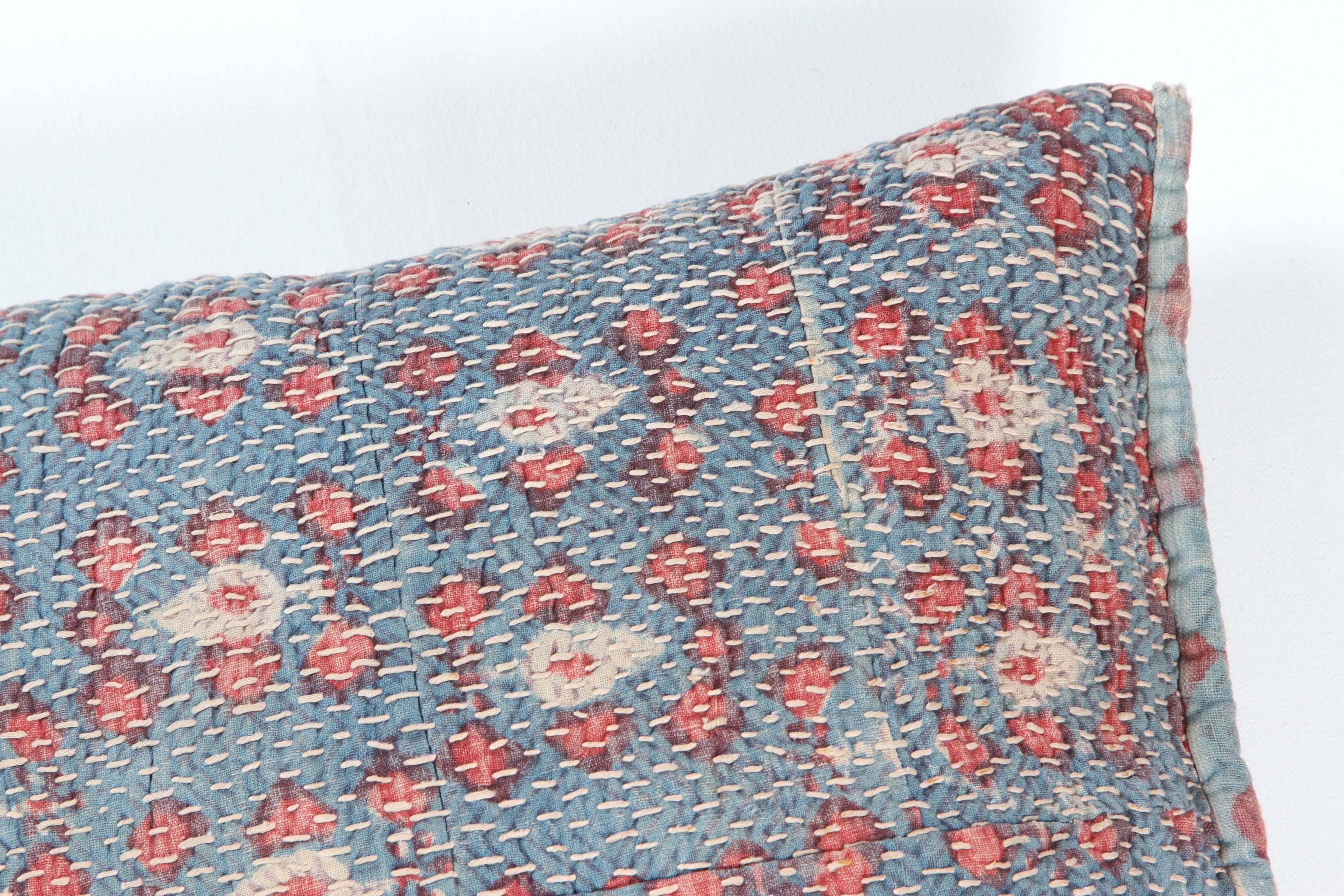 Vintage cotton block printed textile with all-over hand quilting stitches. Used as a storage bag, it has been made into a double sided pillow or cushion with zipper closure, feather and down fill.