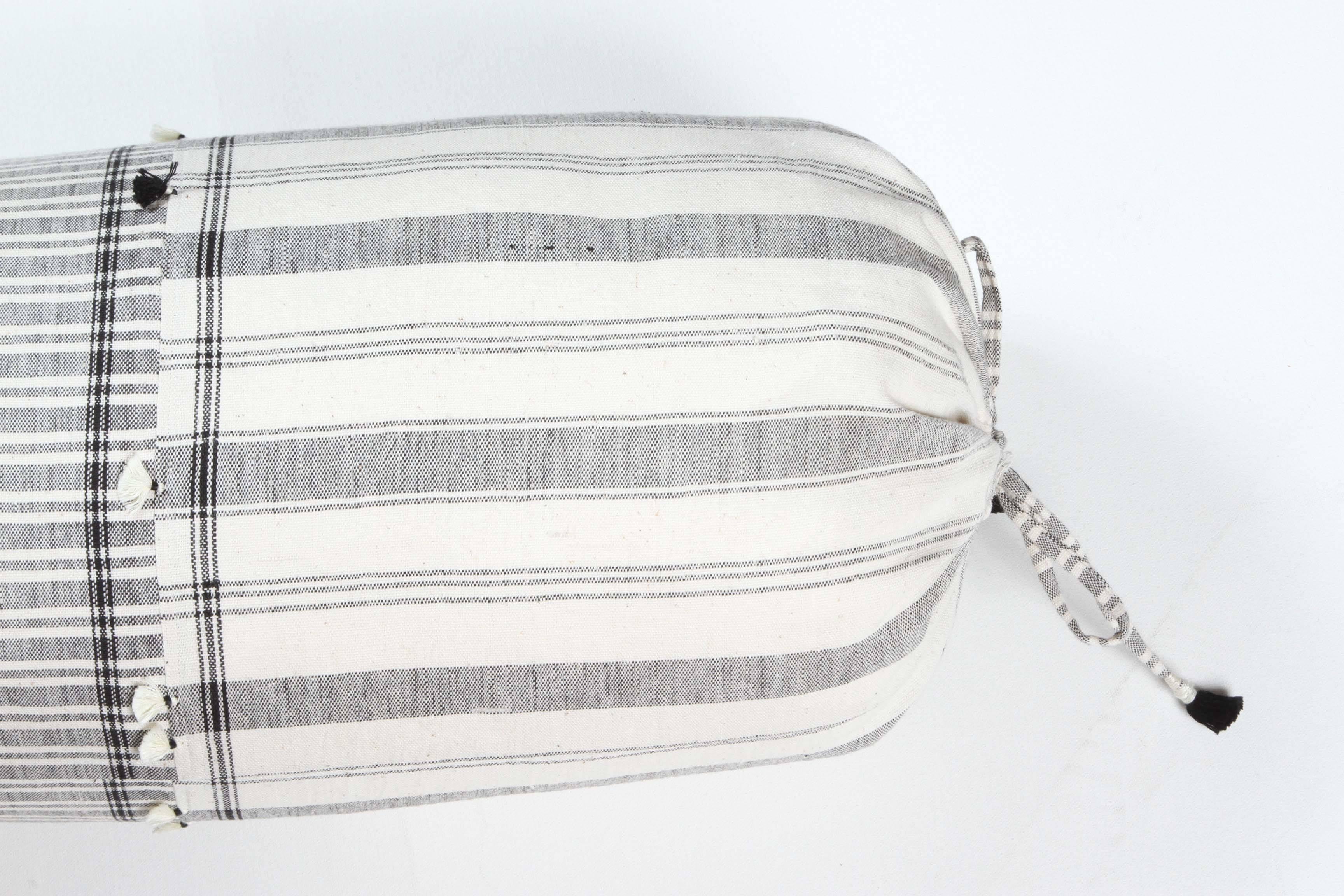 Kala naturally dyed organic cotton from Gujarat, India.  Hand loomed using  traditional Indian textile techniques to produce extra weft woven stripes.  This black and white bolster has added hand knotted tassels.