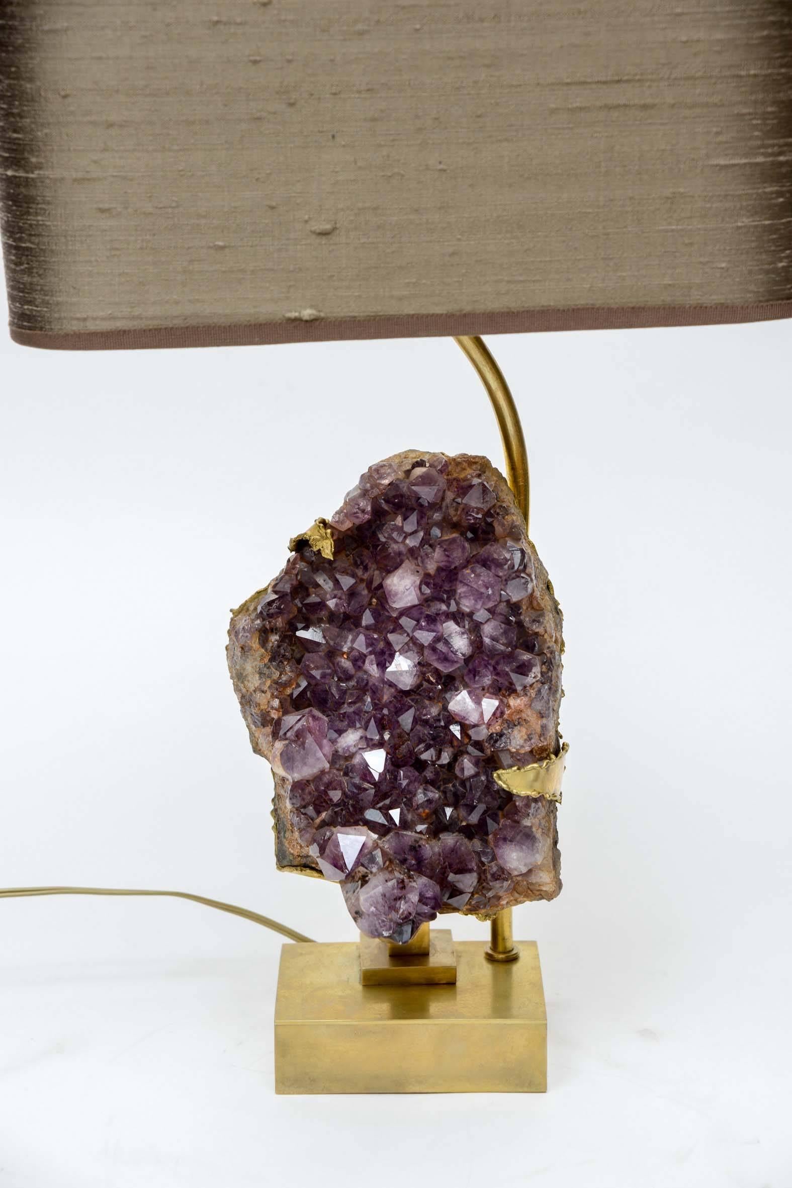 Lovely small table lamps presenting an amethyst set in brass and also resting on a brass plate and cut to follow the shape of the stone. Topped by a new silk lampshade.