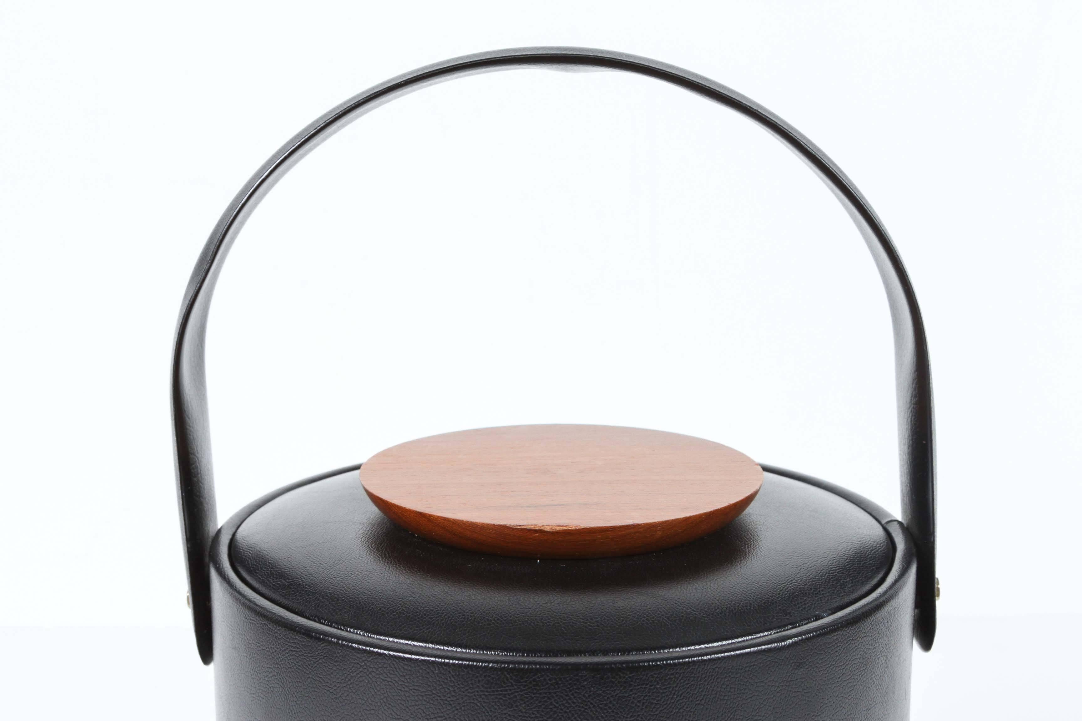 Vintage Georges Briard signed Mid-Century Modern black vinyl covered ice bucket. 
The cover features a teak wood button.
Made in USA.
Great gift for him.
  