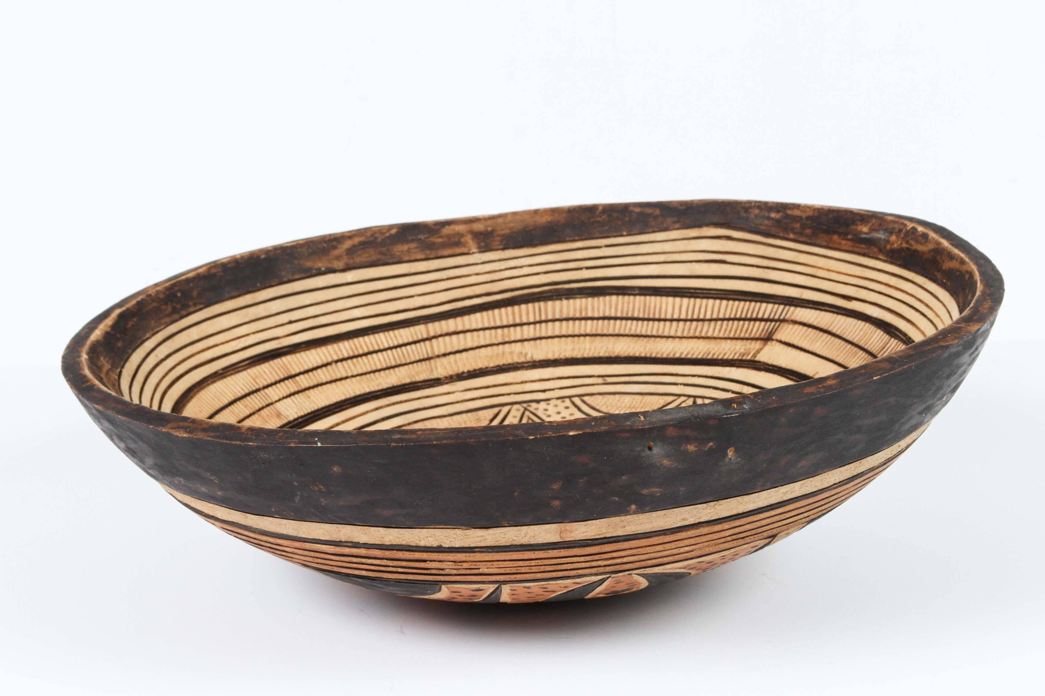 Hand-carved West African Tribal bowl created from a single piece of wood with very simple carved decoration with ethnic designs in front and back, very light wood.
Could be used as a wall decoration or fruit bowl.