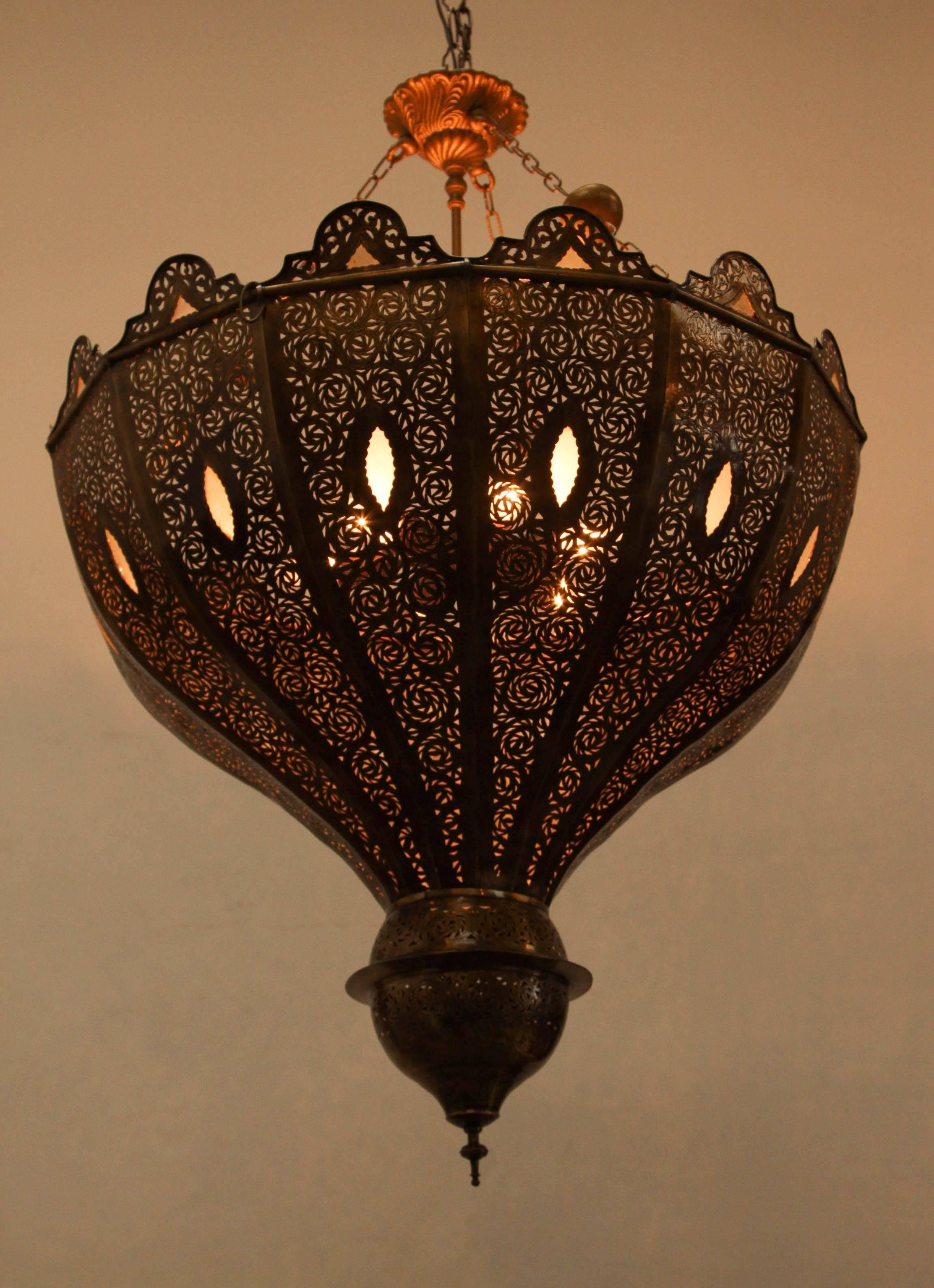 Oversize exquisite filigree pierced brass Moroccan chandelier in Alberto Pinto style.
This exquisite Moroccan light fixture is delicately handcrafted and chiselled with fine filigree designs, adorned with milky glass.
Moorish bronze patina finish,