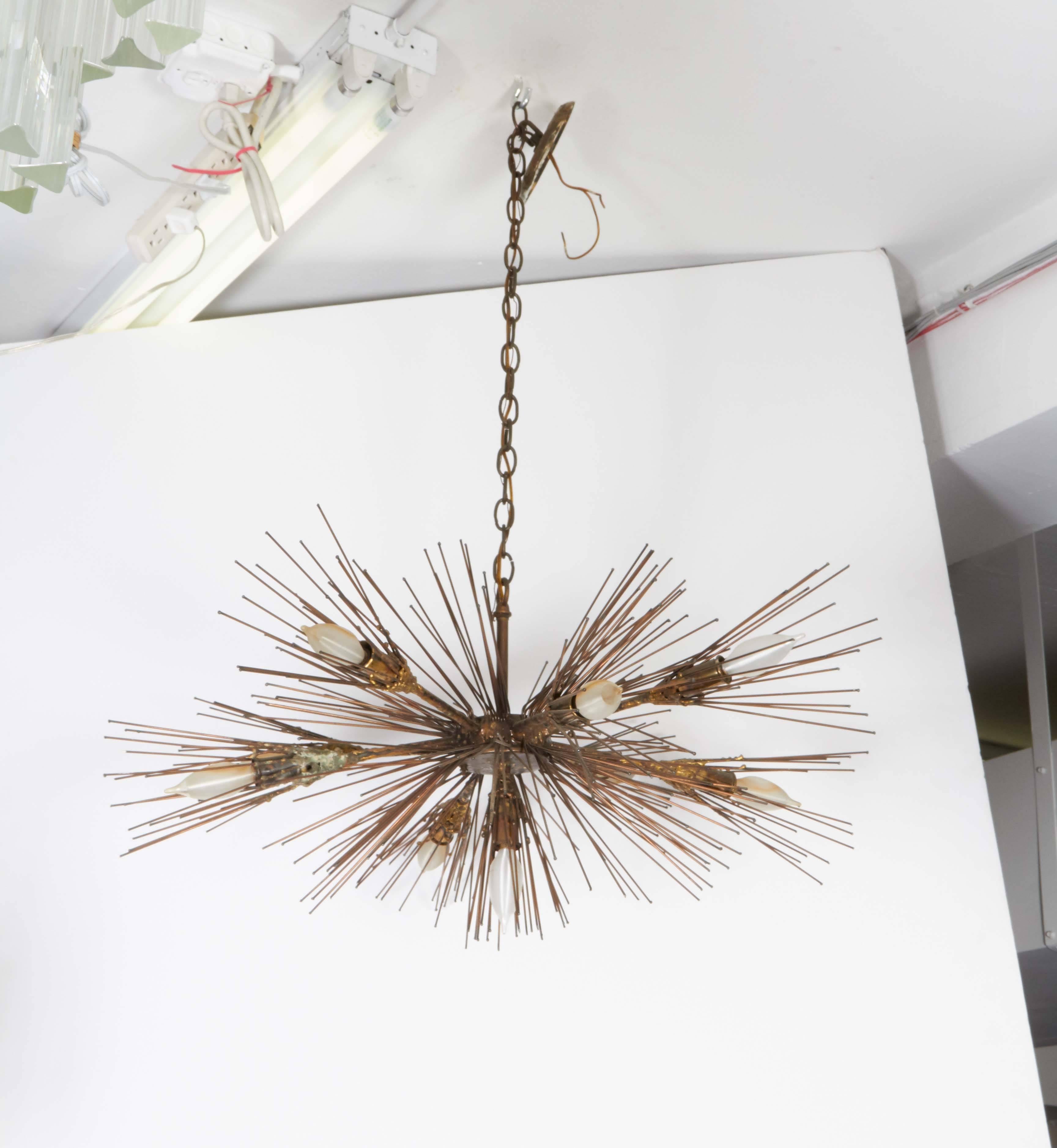 A Mid-Century Modern era urchin Sputnik chandelier, manufactured by the Feldman Company, crafted of soldered metal spires with gilding and verdigris finish. Includes original manufacturer's label. Very good vintage condition, wear consistent with