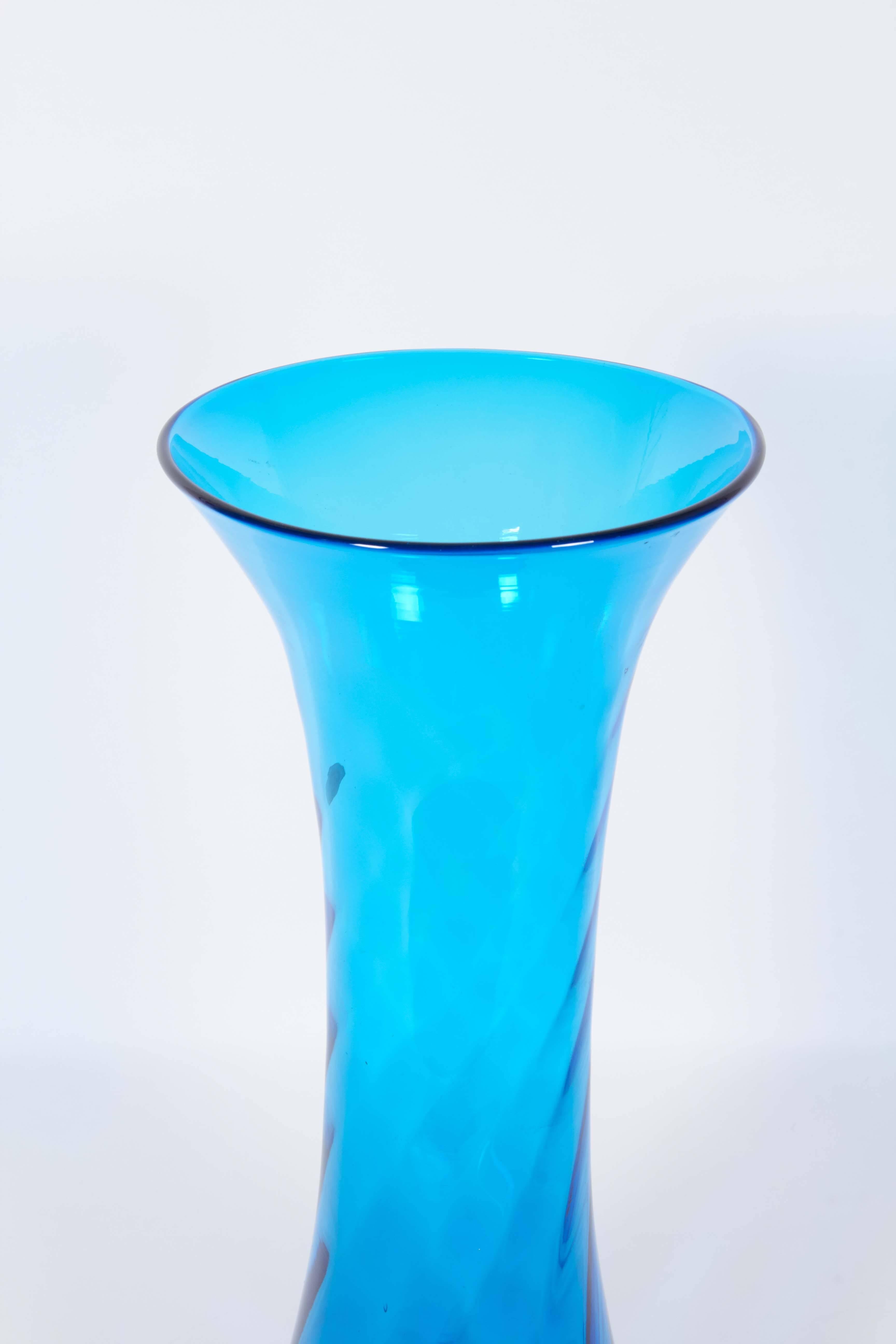 A blown glass floor vase produced, circa 1960s by Blenko Glass of Milton, West Virginia, in bright turquoise of waisted form with rippled detail. Markings include original sticker label. Very good vintage condition, any presence of wear consistent
