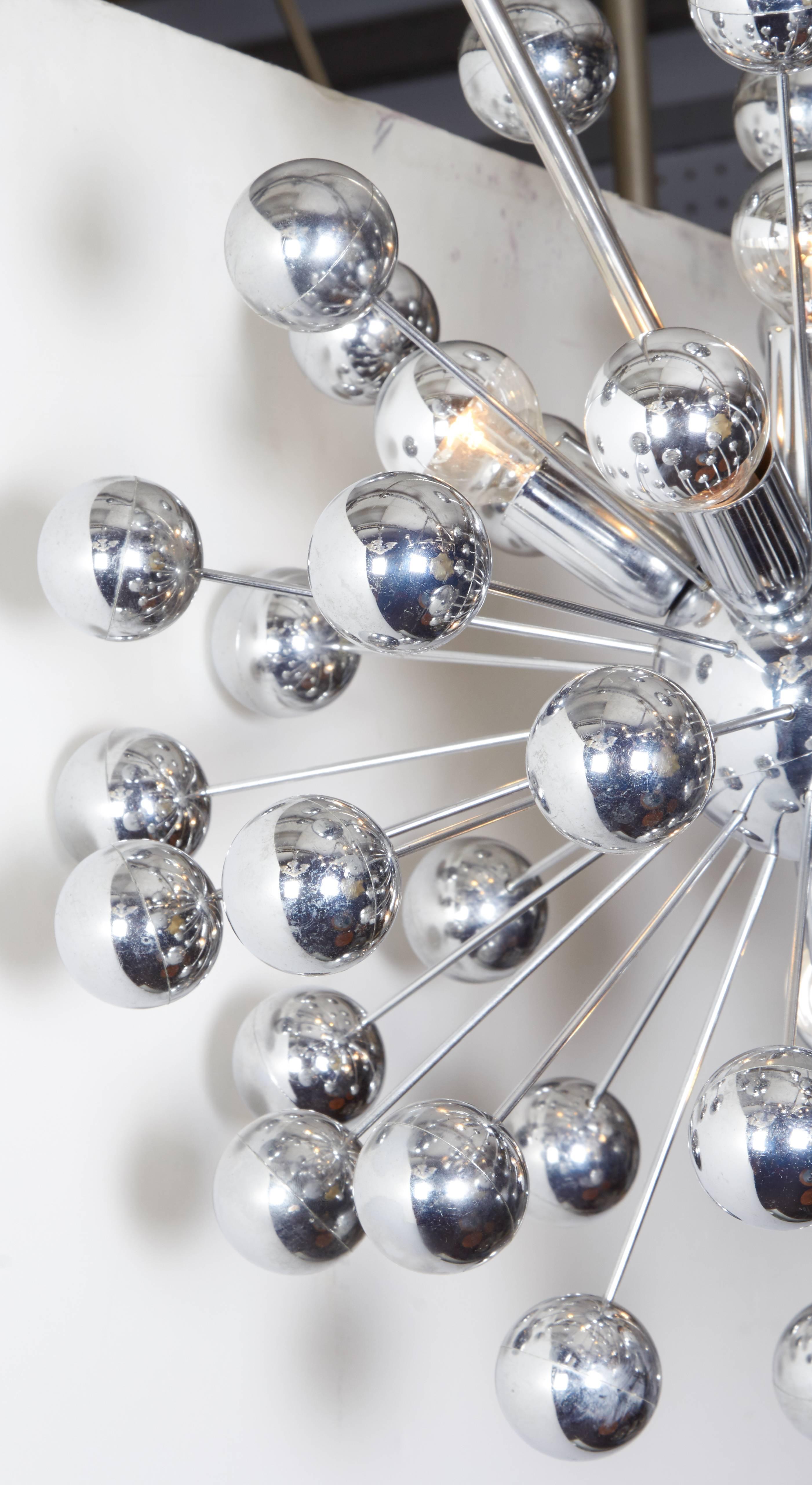 Unique Mid-Century Modern, atomic style chrome Sputnik chandelier. 
This chandelier has an unusual, artistically bent stem which gives it a very sculptural look. Additionally, beside not conforming to the normal vertical drop, it can extend outward