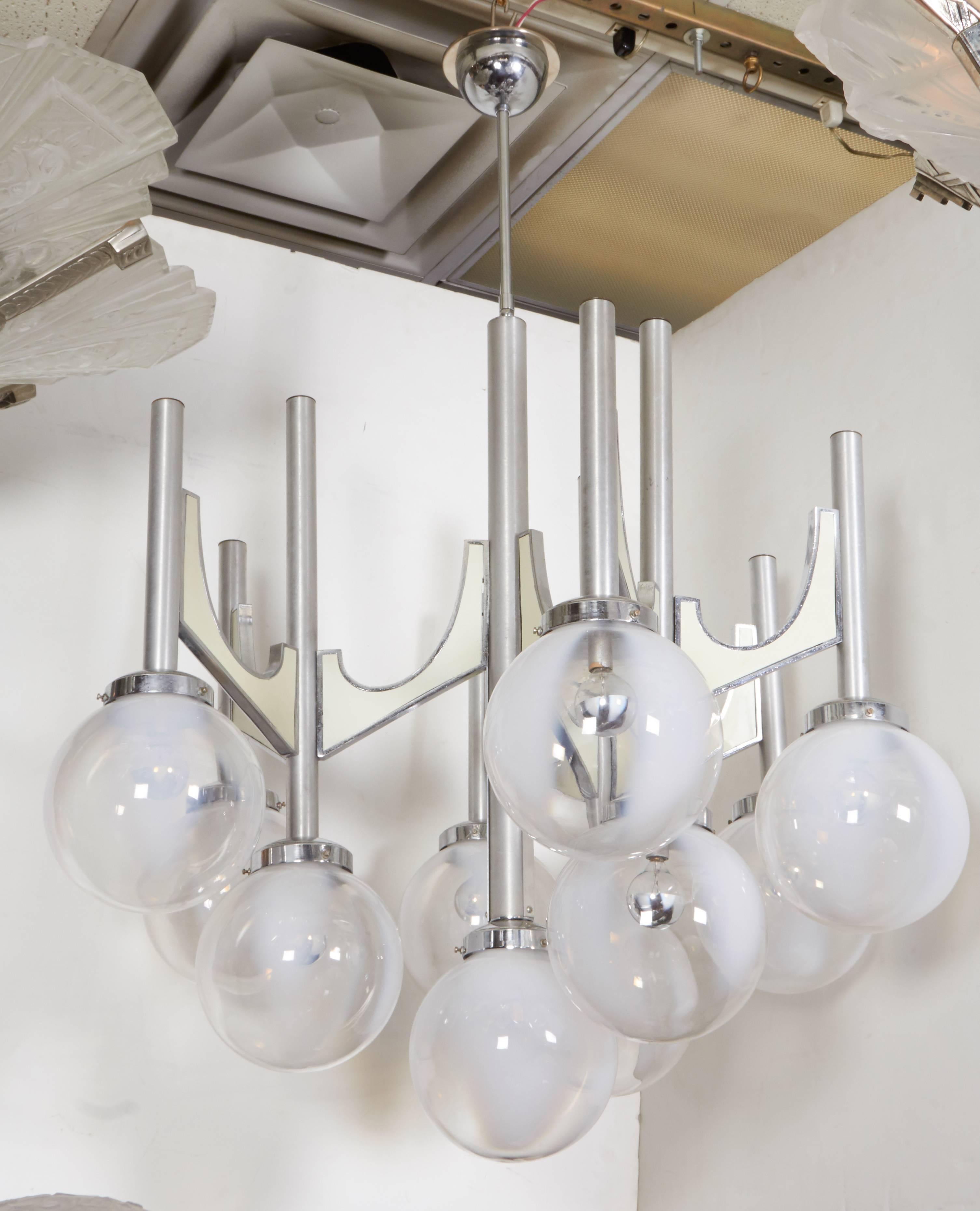 Important and impressive Italian handblown chandelier of grand scale stamped Fonderal Modele depose comprising ten arms in tubular metal with shaped plastic inset arms supporting ten handblown clear and opaque white Murano globes.
Some light scuffs