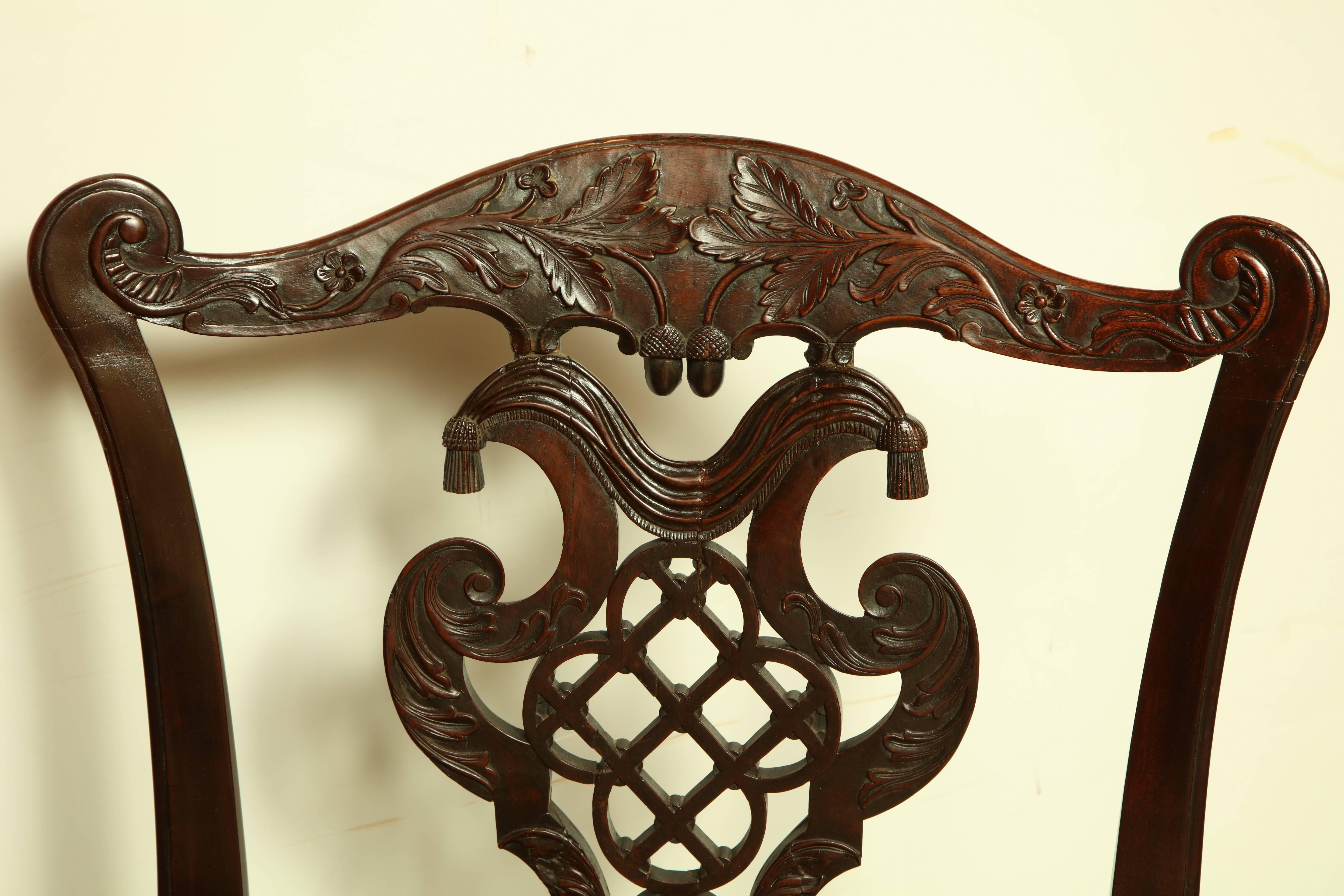 Set of four Irish George III mahogany carved armchairs, with elaborately carved splat of open work and tassels.