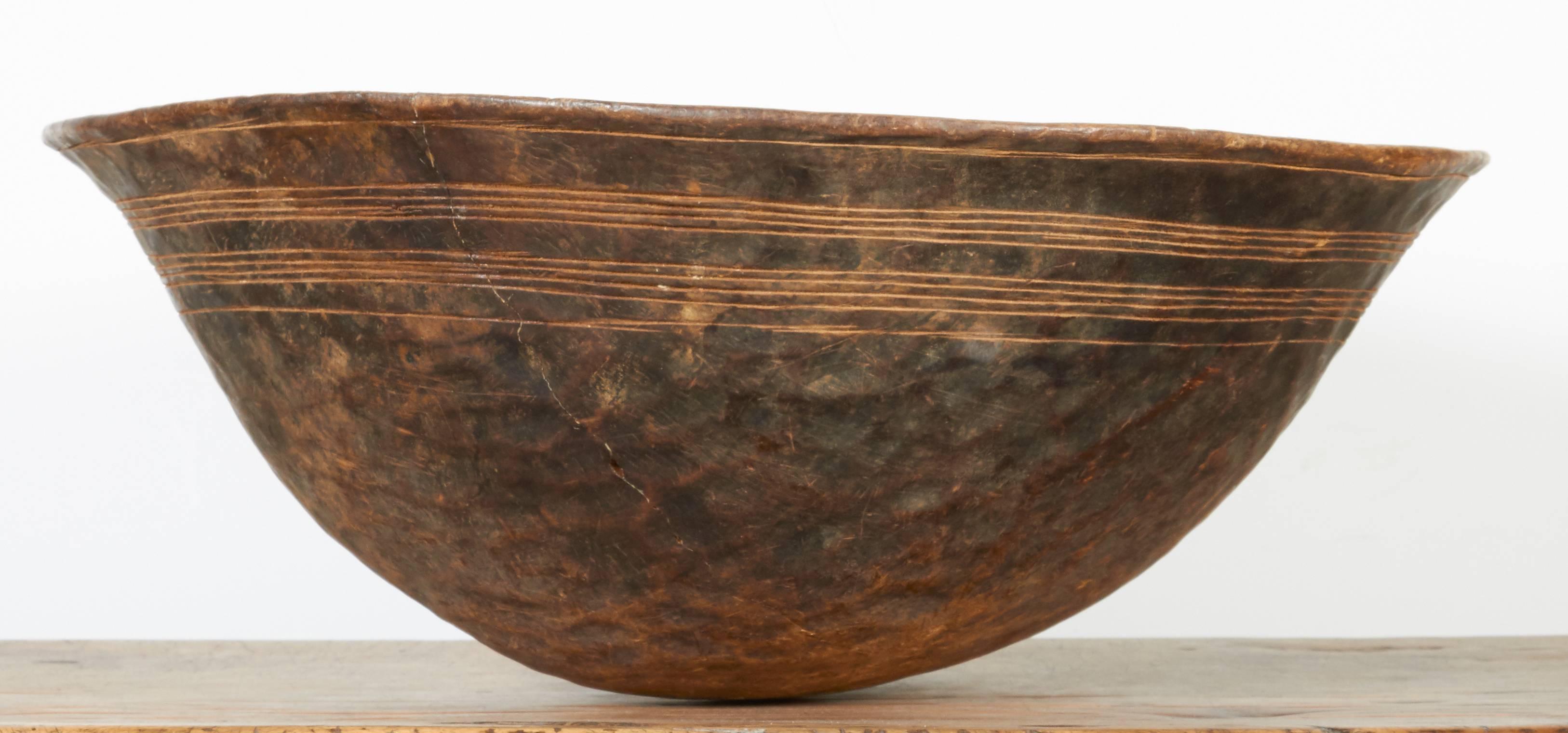 A Classic, gracefully shaped West African food bowl created from a single piece of wood with very simple carved decoration and gorgeous patina showing it's decades of use. 
BT395.