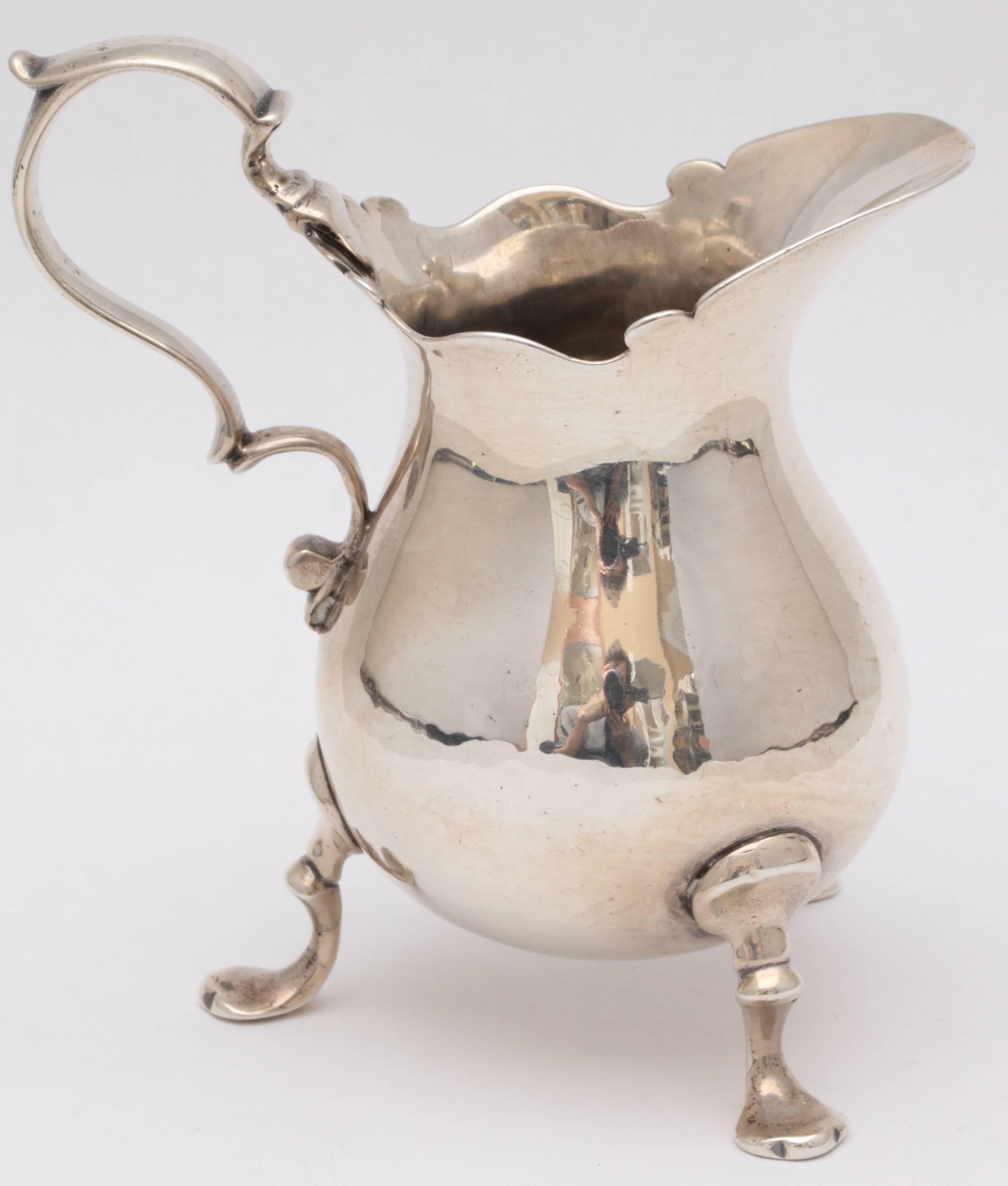 Early Georgian (George II) sterling silver footed cream jug, London, 1741, Humphrey Payne-maker. Measures: 3 3/4 inches high at highest point x 3 1/2 inches wide from end of handle to end of spout x 2 1/4 inches diameter at widest point; legs flare