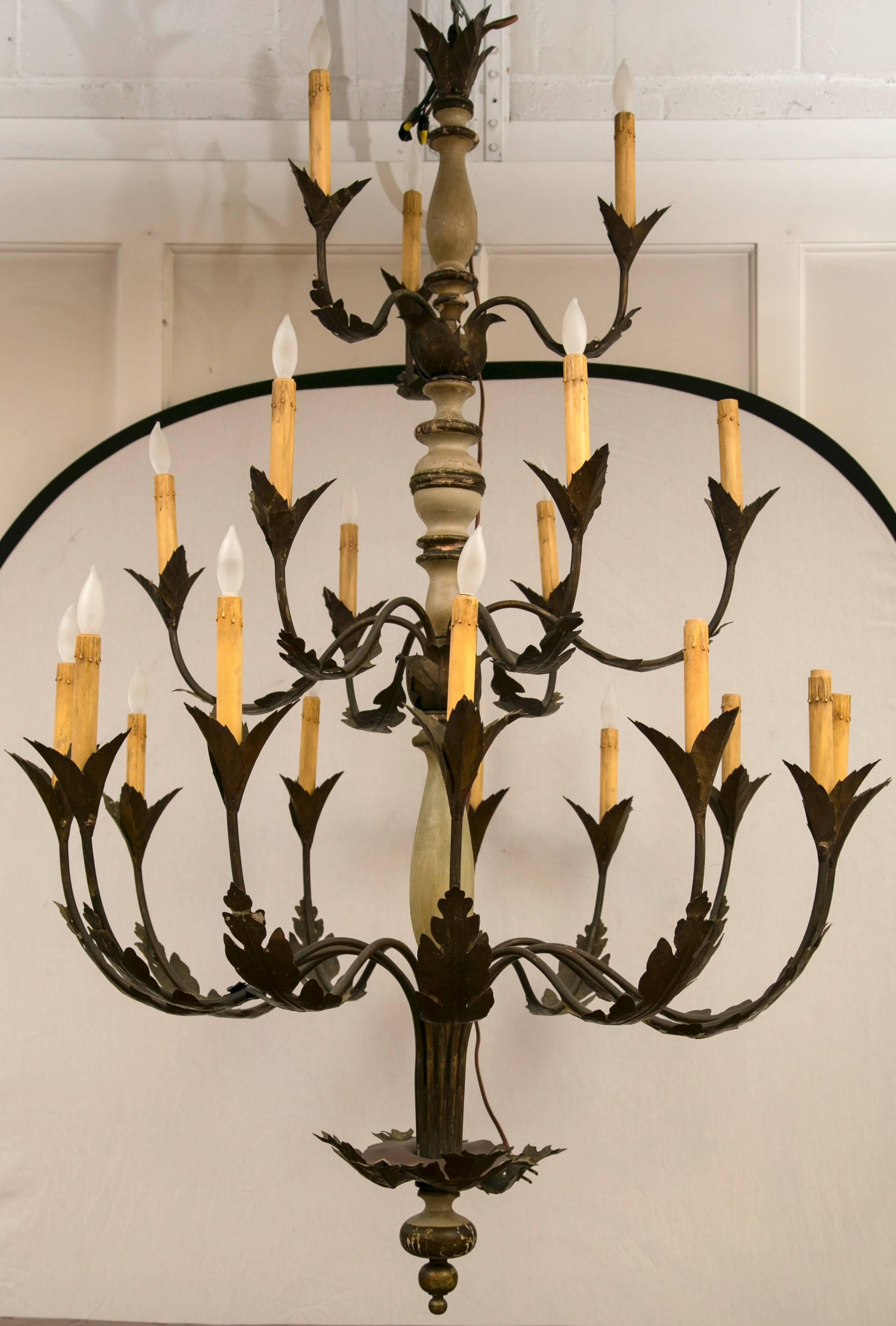 Handcrafted chandelier with 3 tiers and 21 electrified arms. Gilt metal arms surrounding a painted wood center.