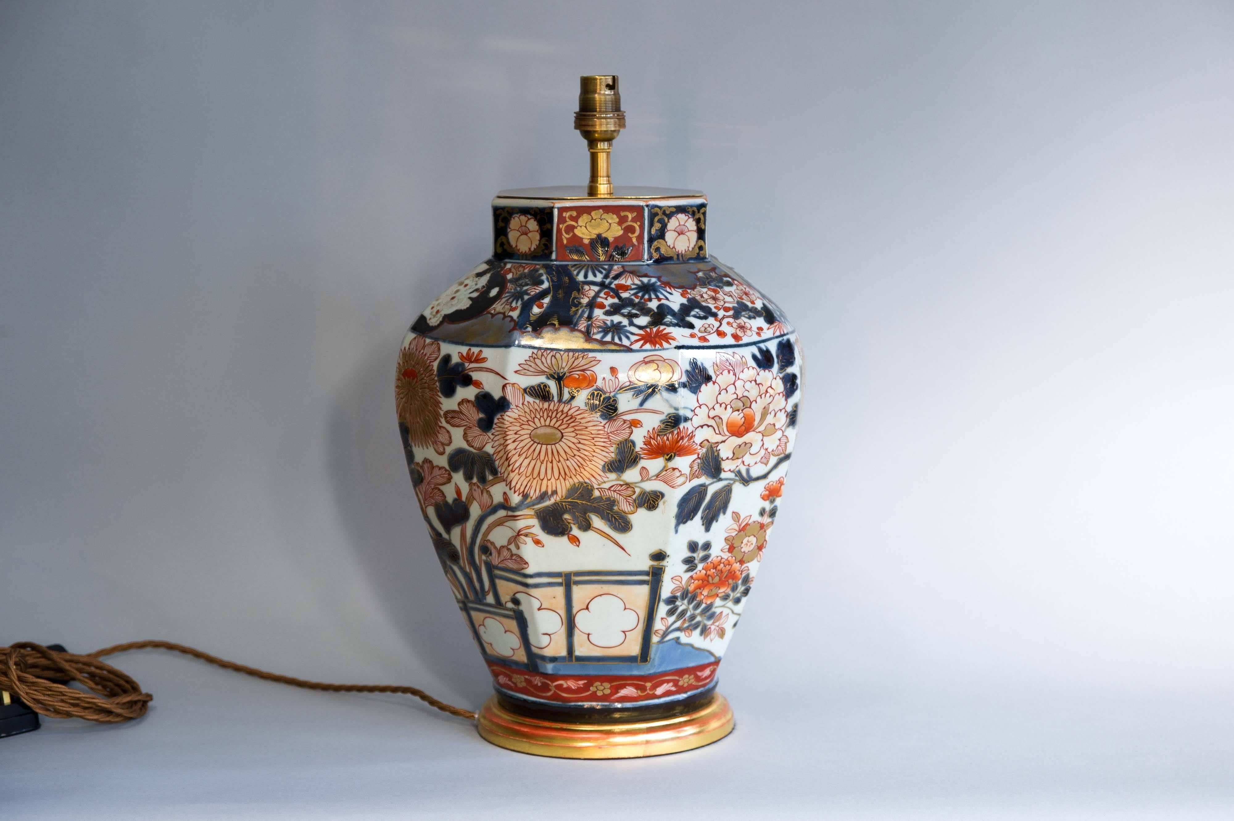 An exceptionally decorated octagonal shaped medium sized Japanese Imari vase dating, circa 1700. Large floral panels showing chrysanthemums and peonies. The collar decorated with kara shi-shi dogs on black backgrounds. The vase features an