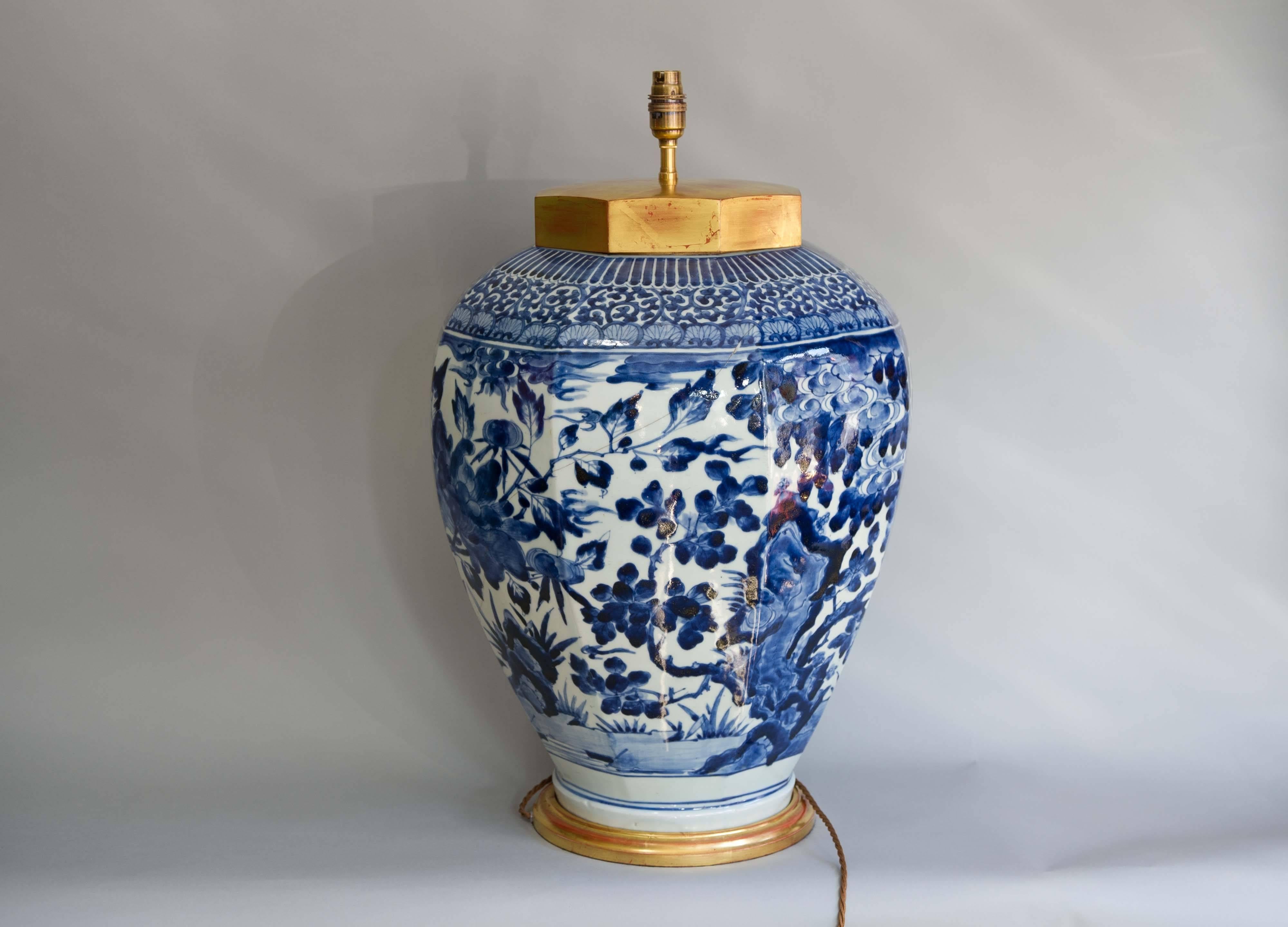 A large late 17th century Japanese octagonal Arita blue and white vase, circa 1680. The vase is of octagonal baluster form, boldly painted with rocks and large blossoming foliage composed around the entire body within stylized borders. This vase has