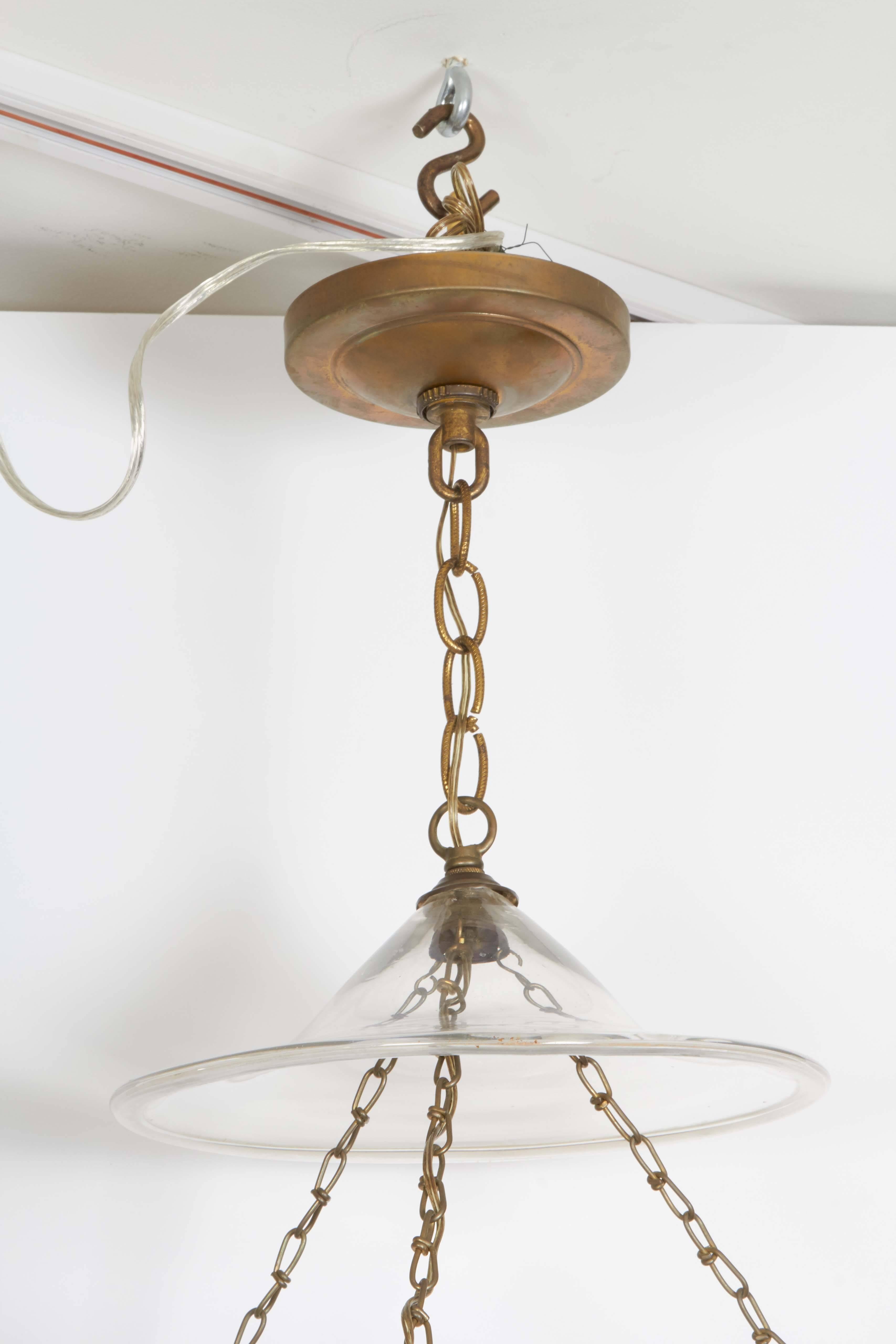 A pair of George III style gilt brass hall lanterns from the George F Baker House, tripartite chain suspending a glass hurricane shade fitted with single Edison socket, circa 1930.