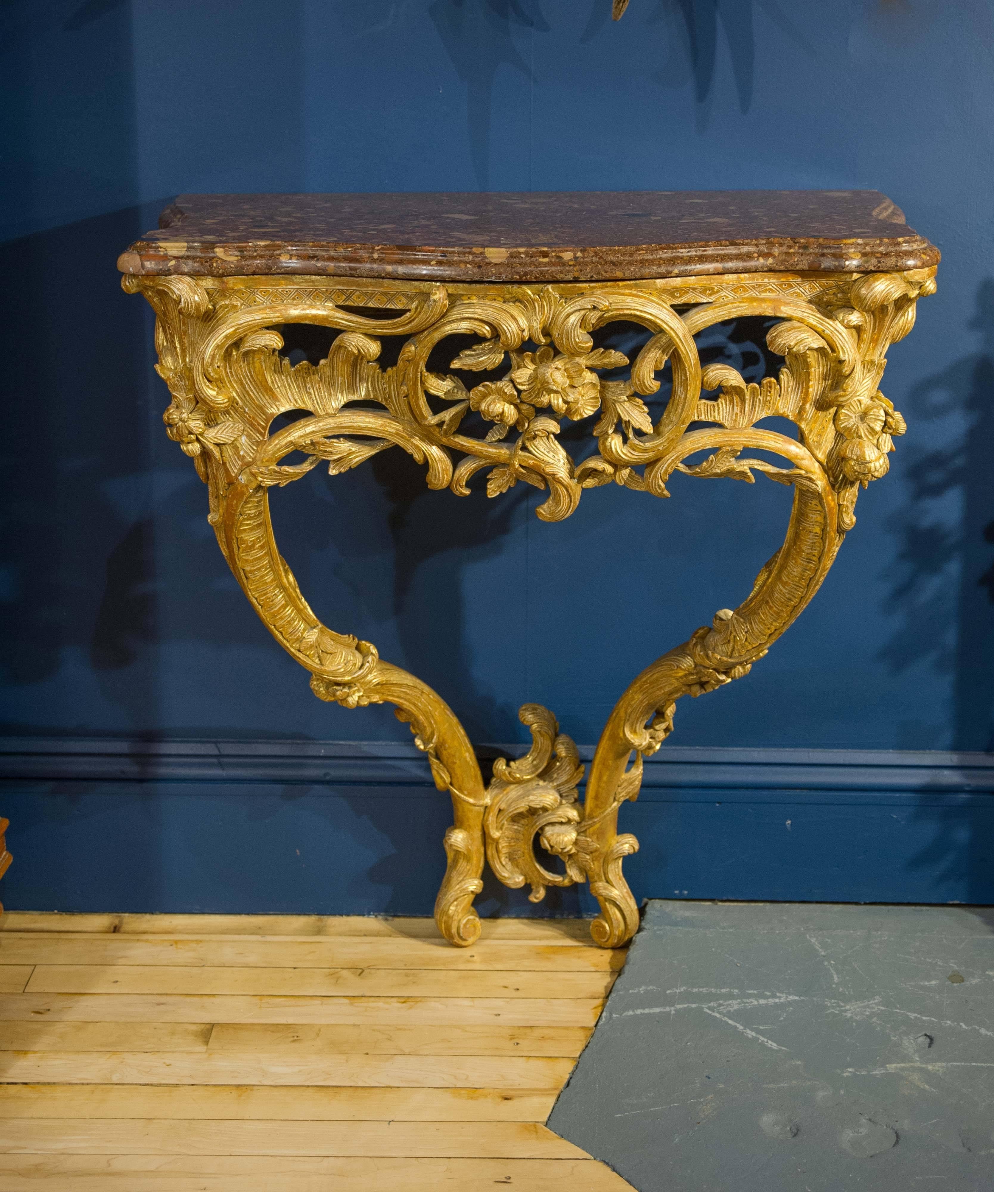 This magnificent late 18th century giltwood console table features a highly ornate but delicately designed series of scrolls, leaves and florals. The two supporting cabriole legs are joined at the base with a series of scroll motifs and Stand on