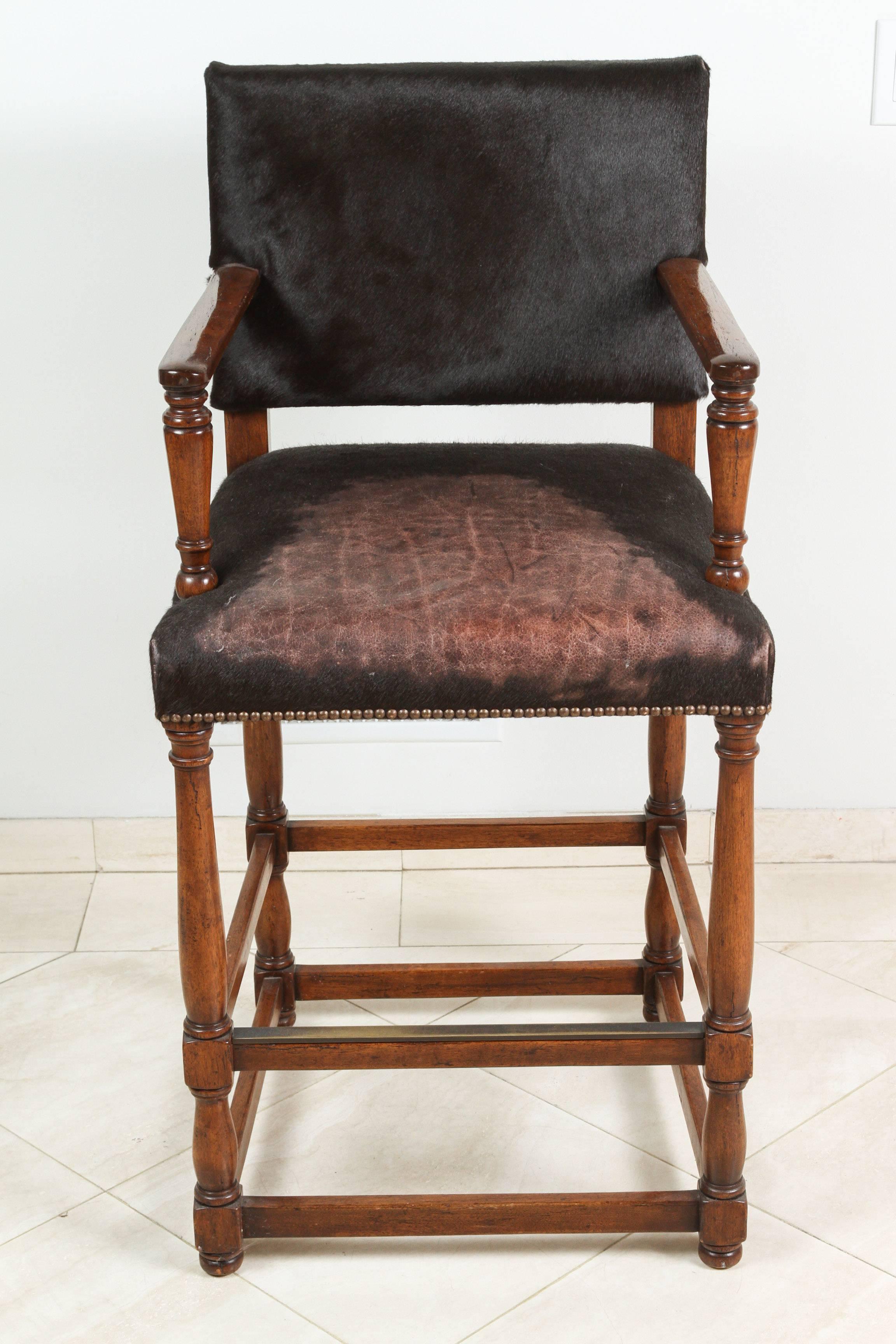 Set of five large fabulous black hide covered bar or counter stools with elegant carved armrests, made of solid hand-carved wood.
Each has sumptuous black hide upholstered backs and seats with brass studs.
Deep and rich patina on the wood and the