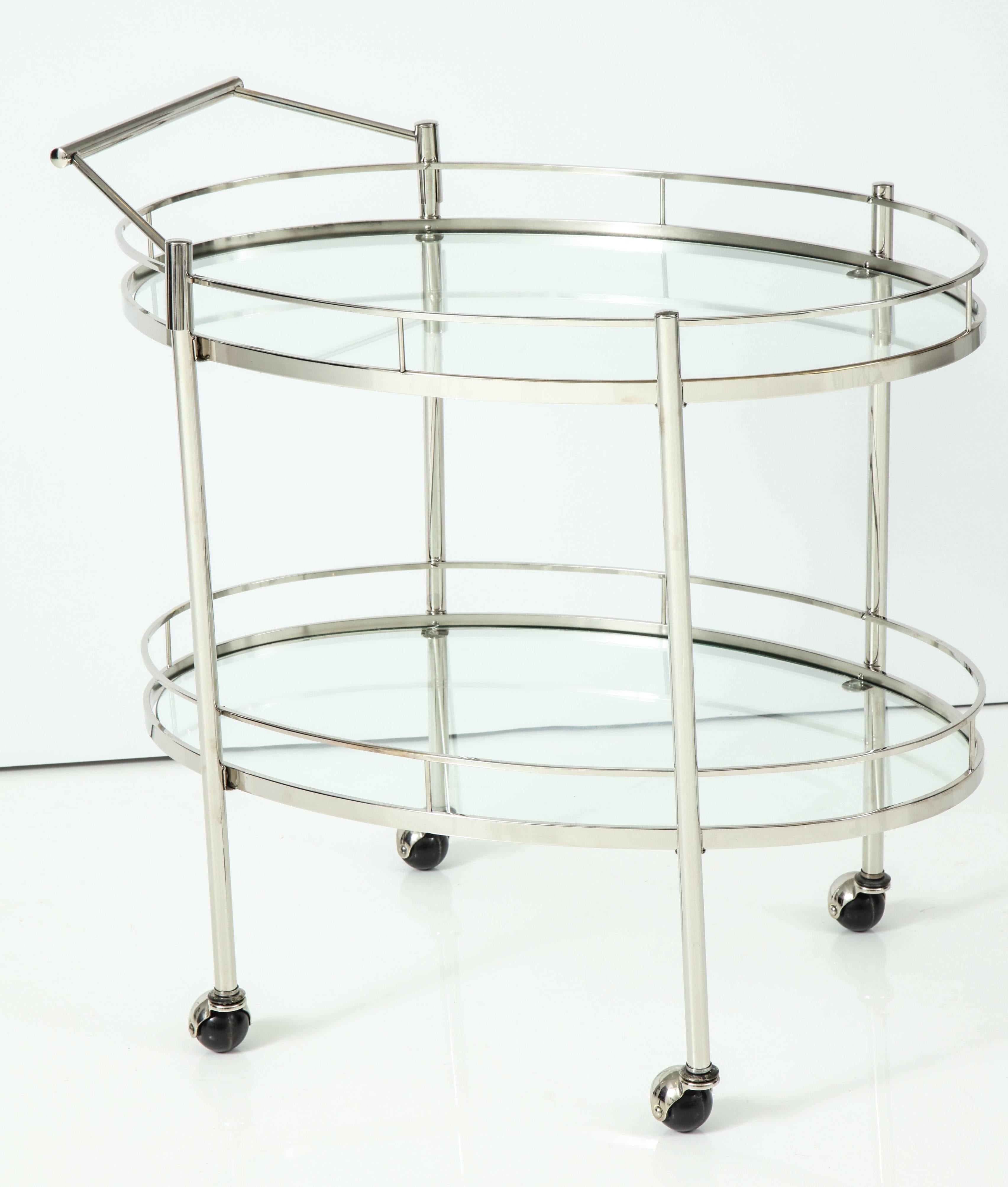 Fantastic polished nickel two-tier bar cart with glass shelves and hooded ball casters.