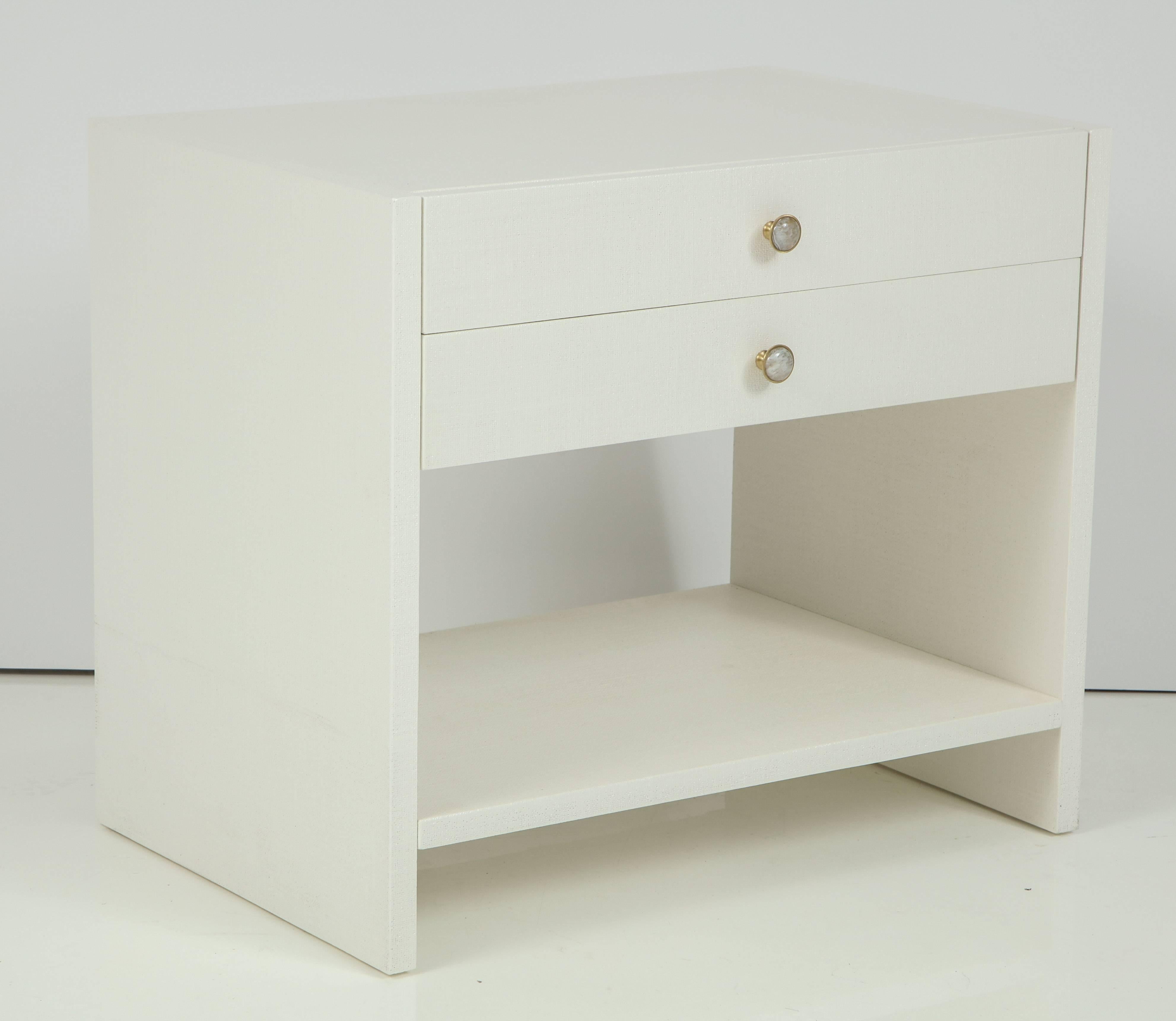 Pair of 1970s custom-made nightstands in off-white lacquered linen and cabachon crysta quartzl and brass knobs. Each nightstand has two pull-out shelves and shelf. Mint restored condition.