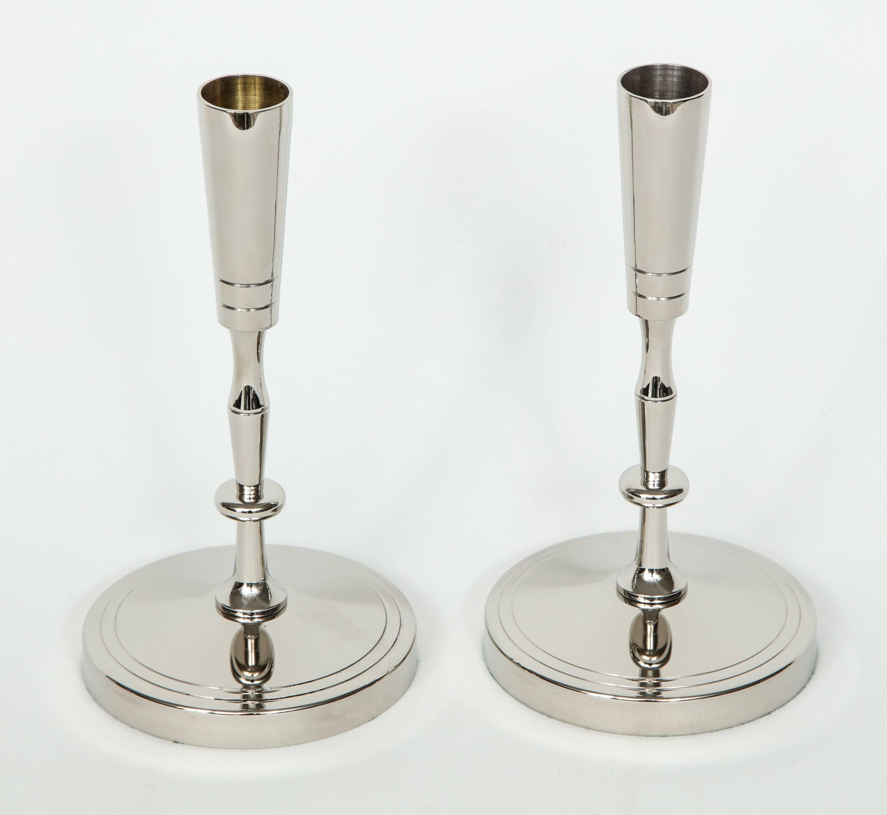 Pair of polished nickel candlesticks with a circular base and sinuous stem designed by Tommi Parzinger for Dorlyn.