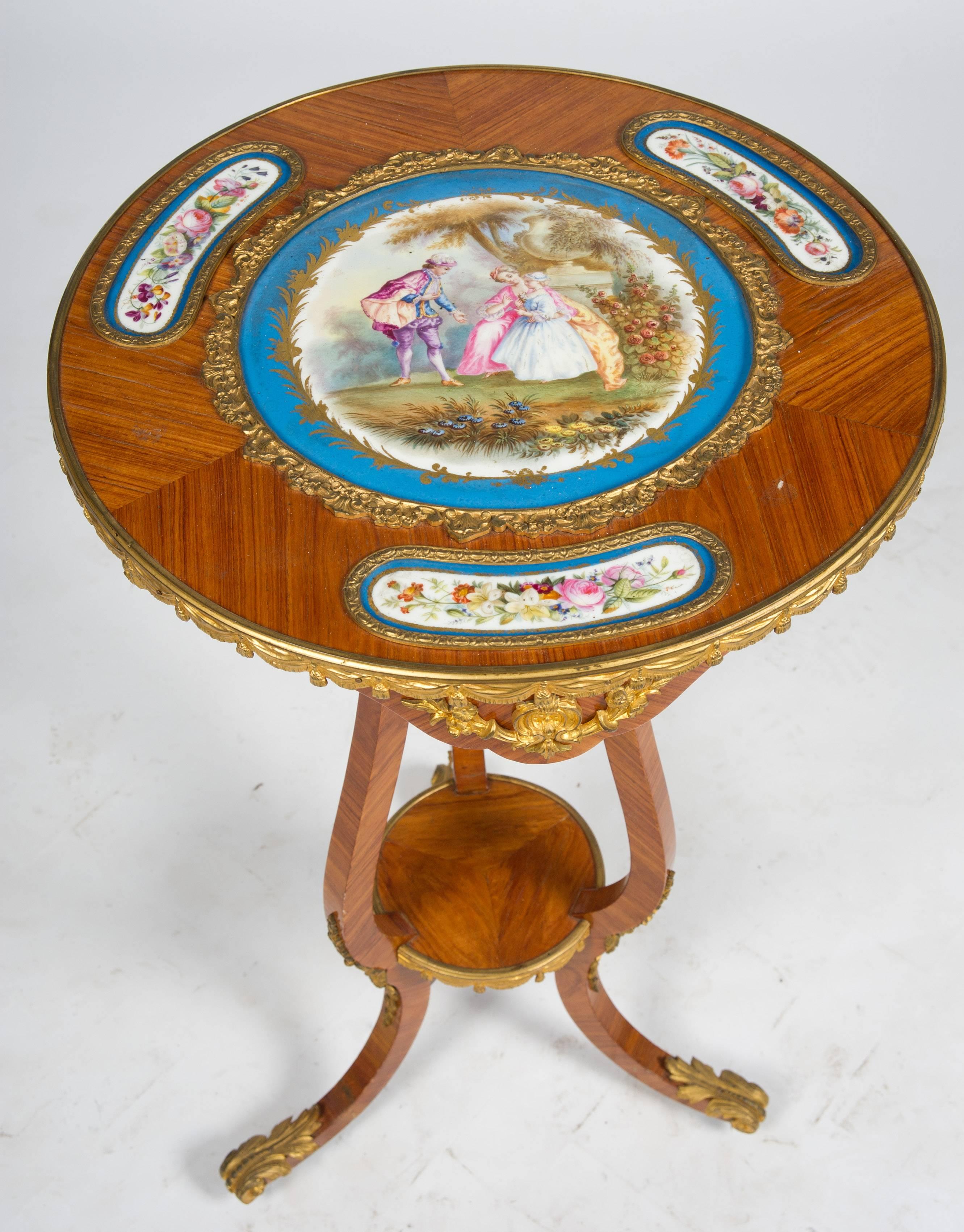 A charming 19th century French kingwood, ormolu-mounted occasional table with inset French 'Sevres' porcelain plaques to the top. The central plaque depicting a romantic scene, the others with flowers all within a turquoise border. Raised on three