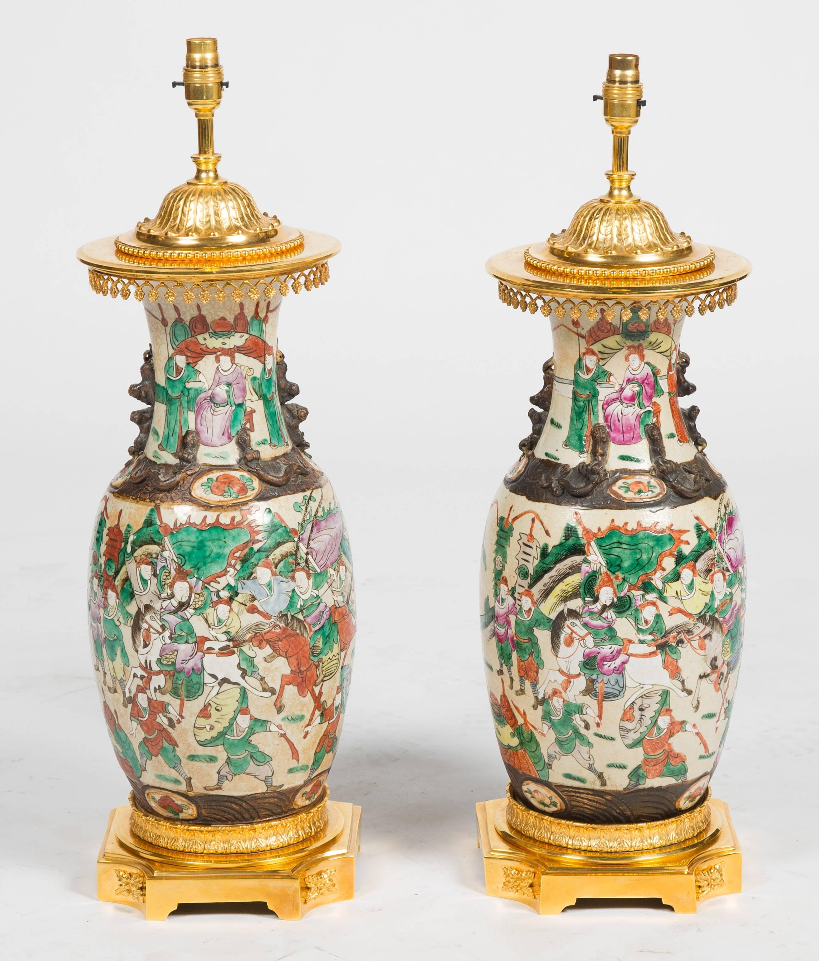 An impressive pair of 19th century Chinese crackleware vases, having classical scenes of warriors on horseback and mounted with gilded French ormolu mounts.