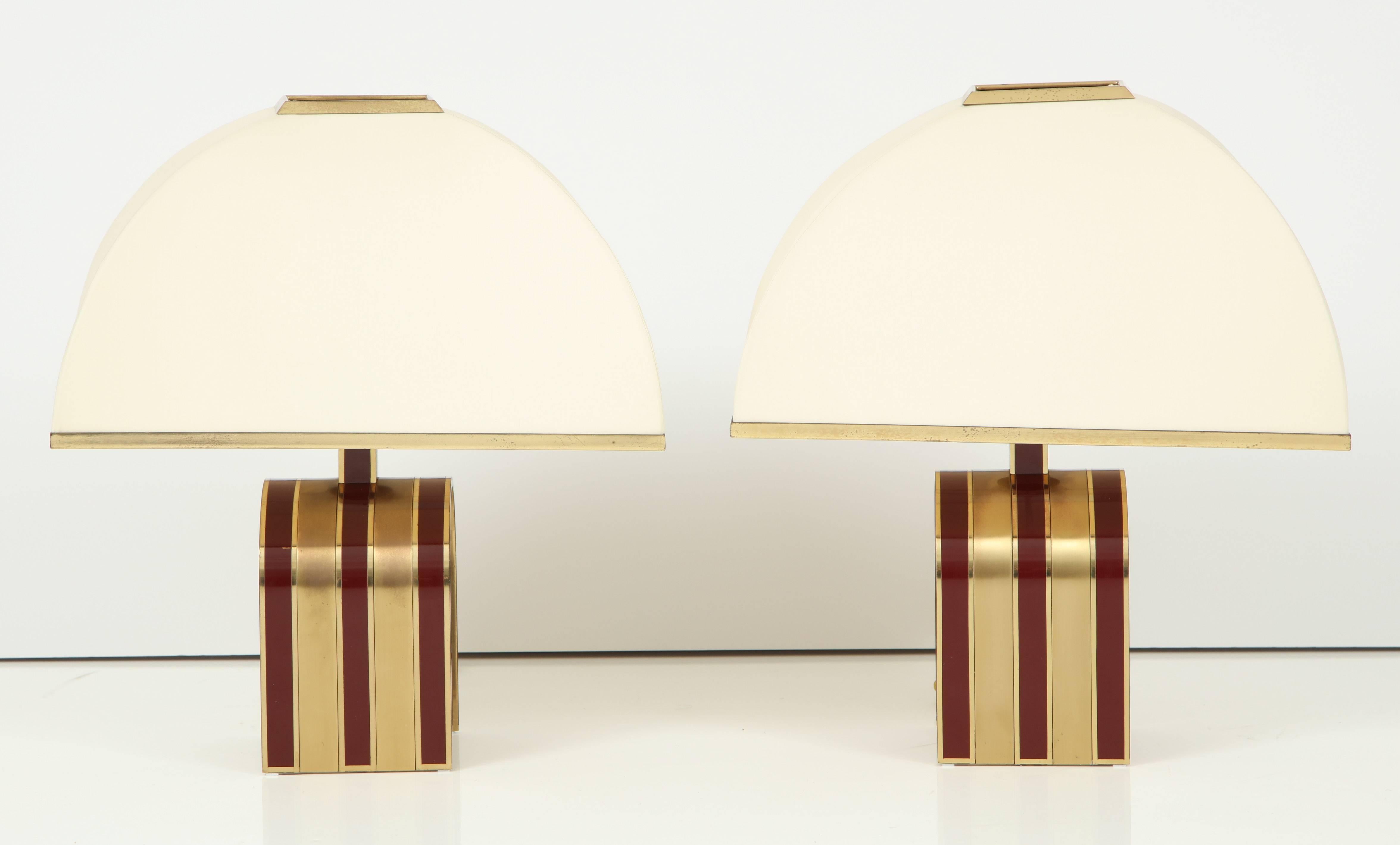 Pair of original U-shaped lamps attributed to Romeo Rega. Base is comprised of alternating enameled deep red (burgundy) and brass/gold stripes. Original dome shaped lampshades with solid brass edges. Rewired for U.S. use.

On display at the