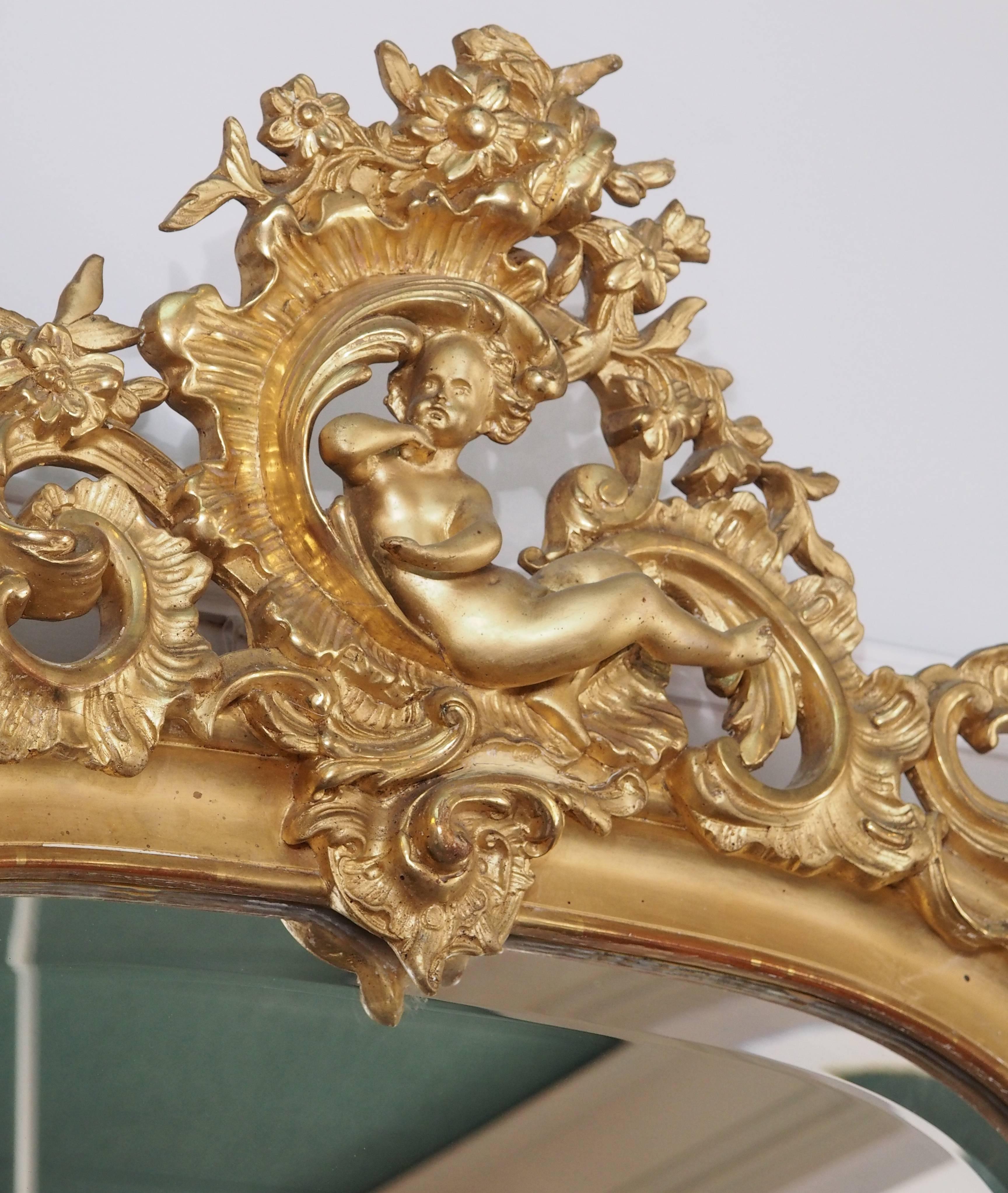 Finest quality antique French gold leaf mirror with beveled glass. Cherub.