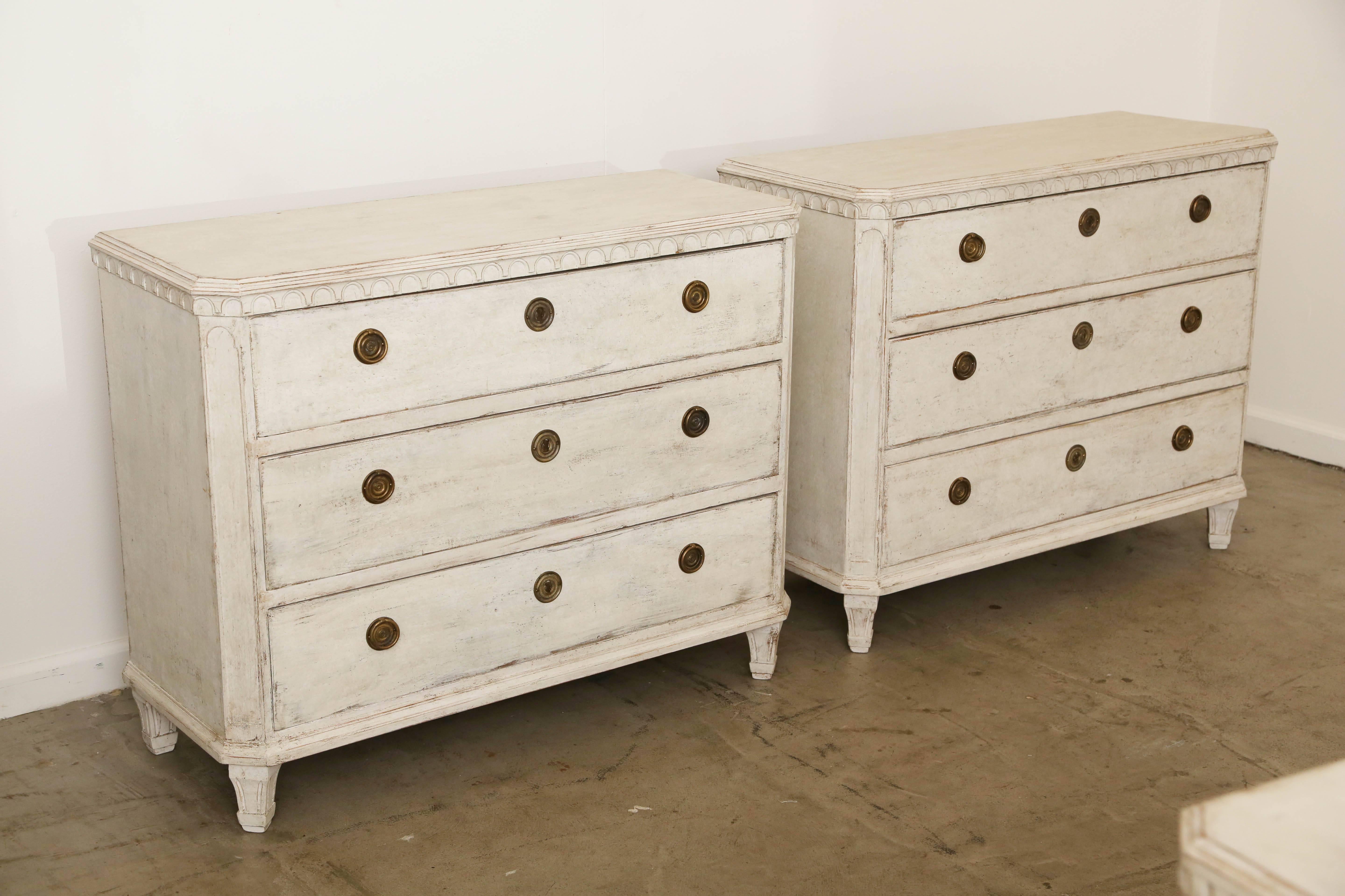 Pair of antique Swedish Gustavian style painted chests, late 19th century
Simple painted tops above a lovely crisp carved arched border, cut off corners with carved panels, Classic tapered fluted legs, three drawers. Painted in a
distressed Swedish